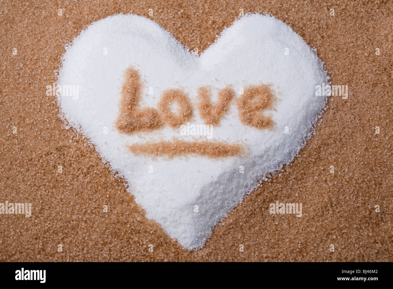 The word love written on a white sugar heart shape within a base ...