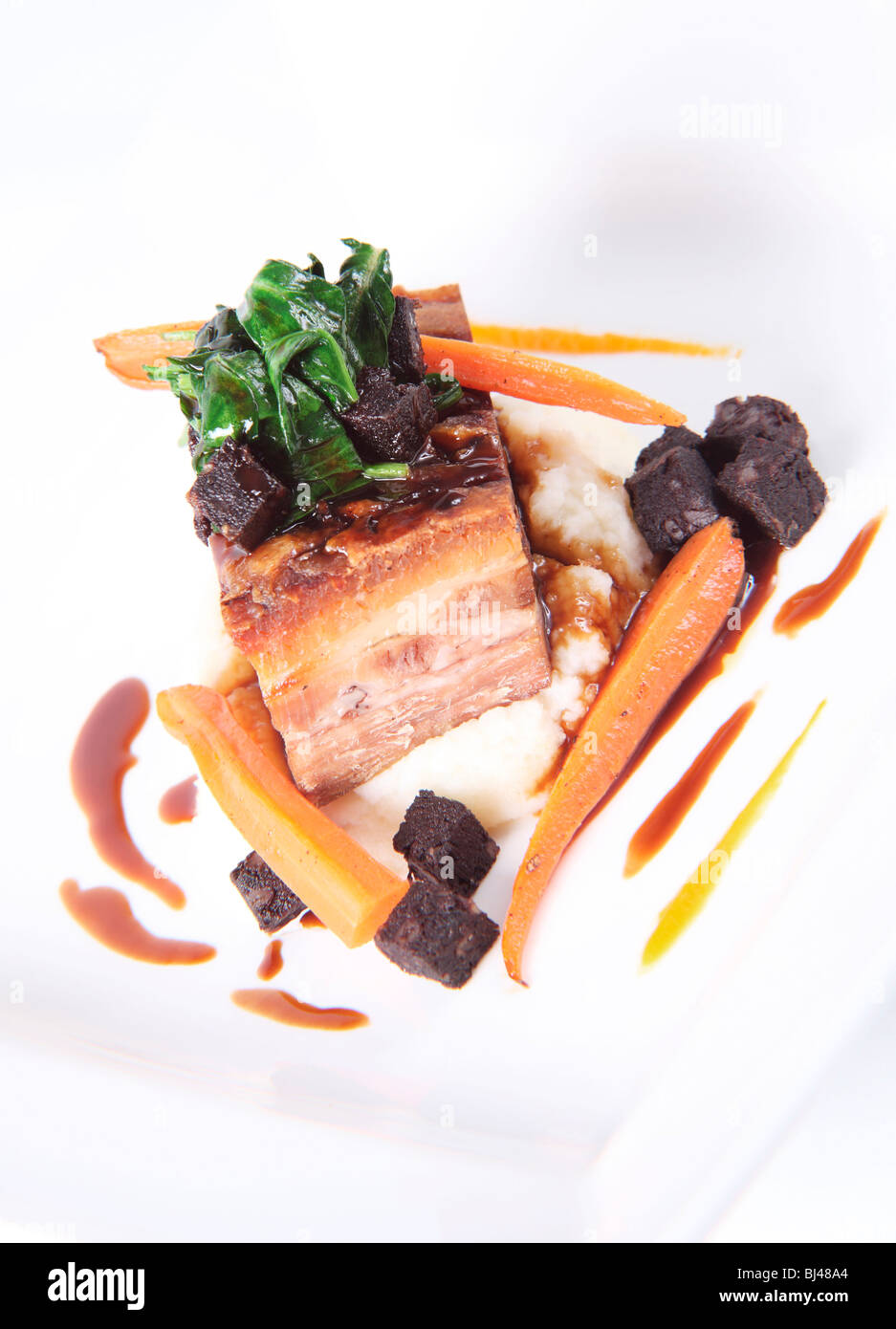 Roasted Belly of Pork with Black Pudding and Bacon Mash Stock Photo