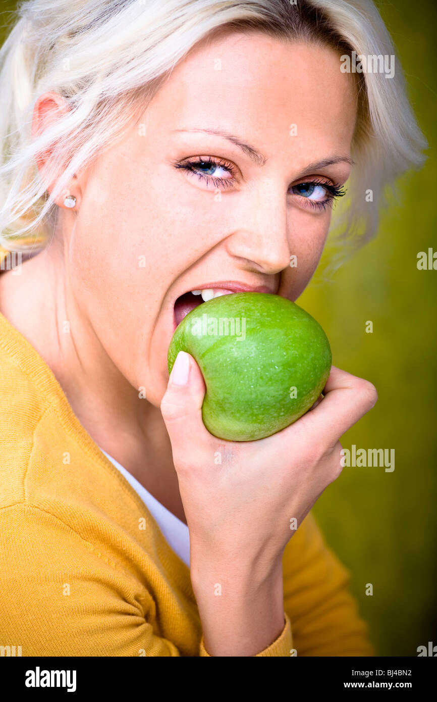 Young woman biting into apple Stock Photo