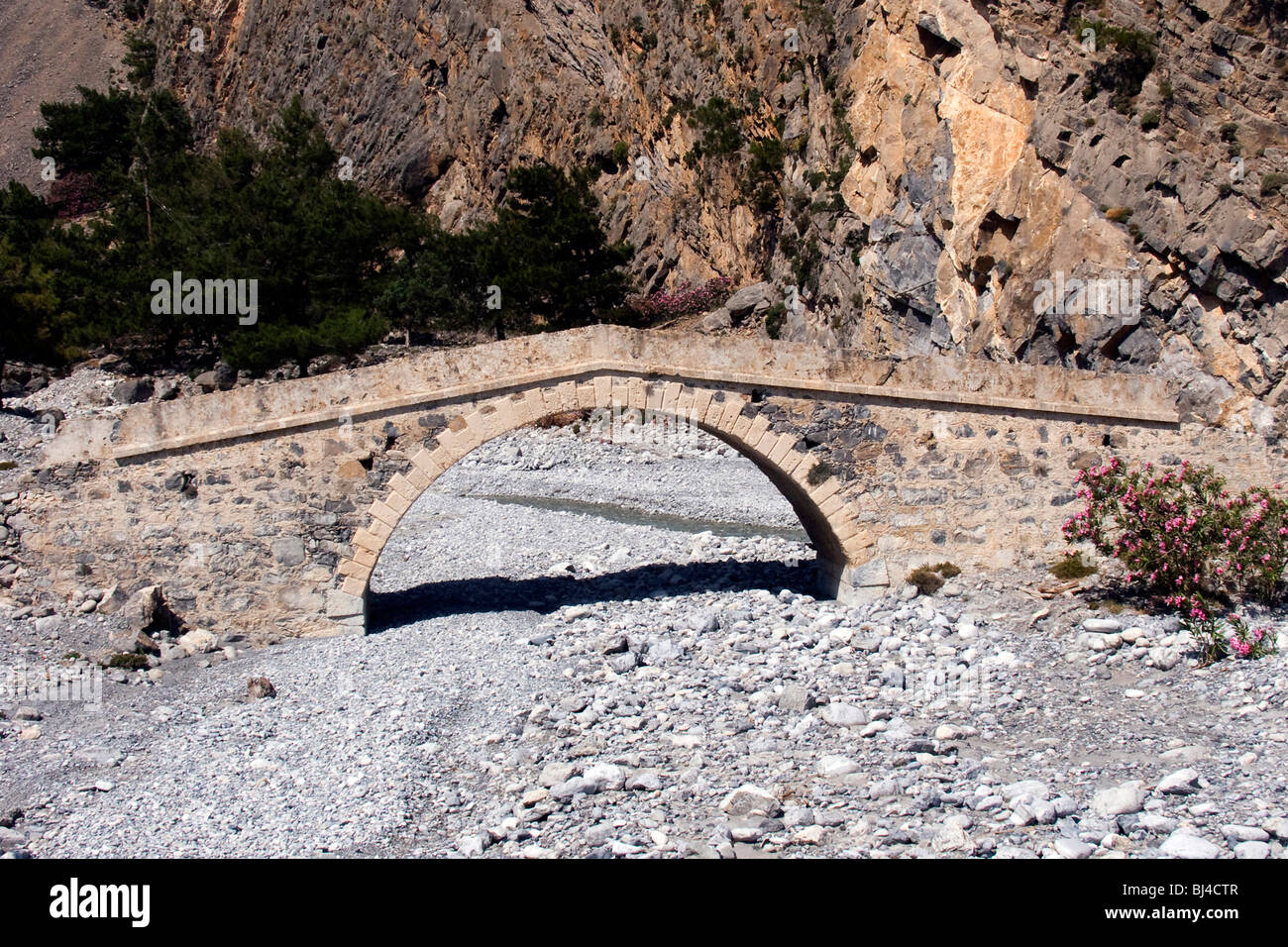 An old bridge from the Roman period spans the dry river bed in the Samaria Gorge in Agia Roumeli, Crete, Greece, Europe Stock Photo