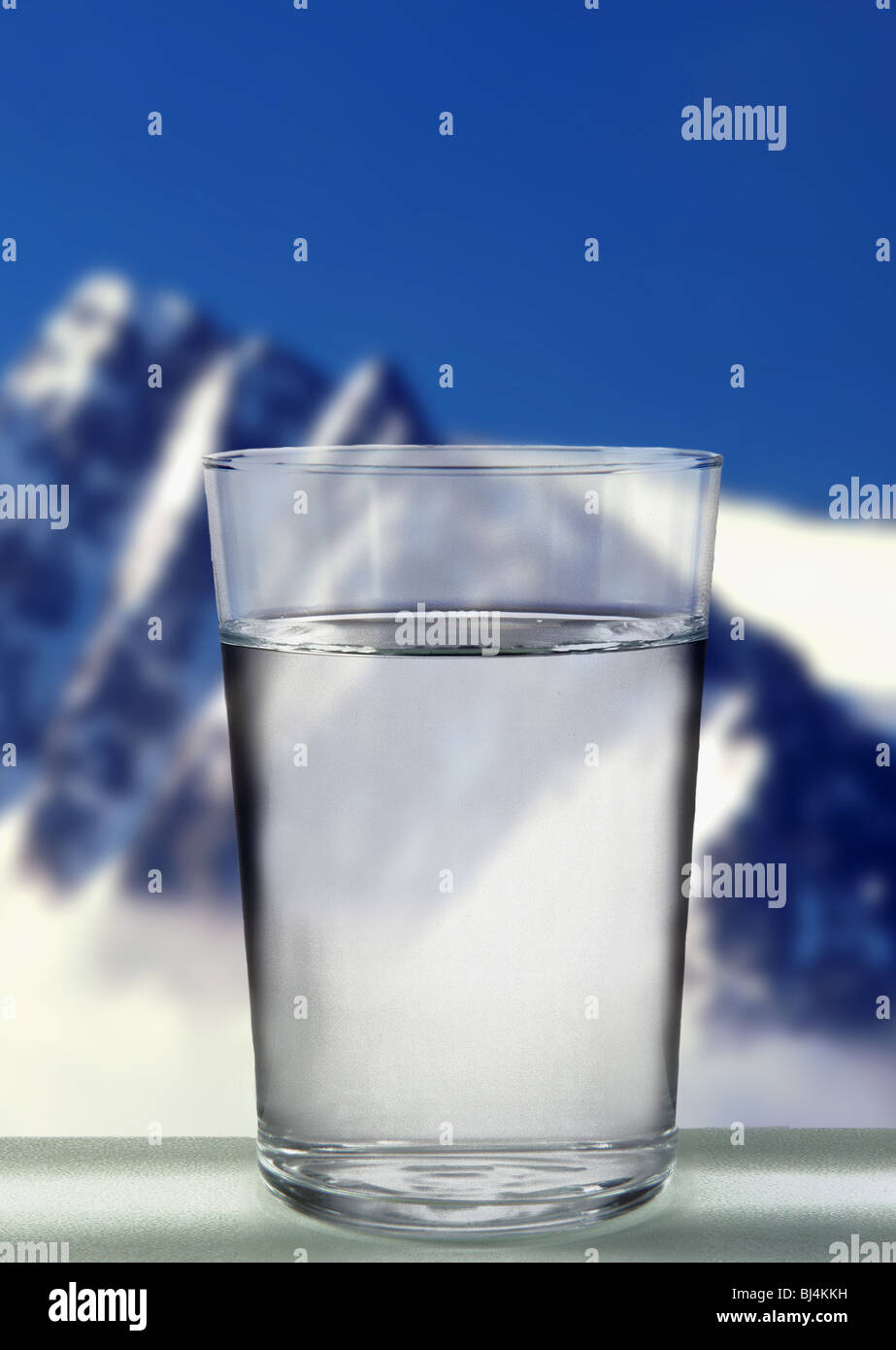 Glass of water on a background of snowy mountain. Stock Photo
