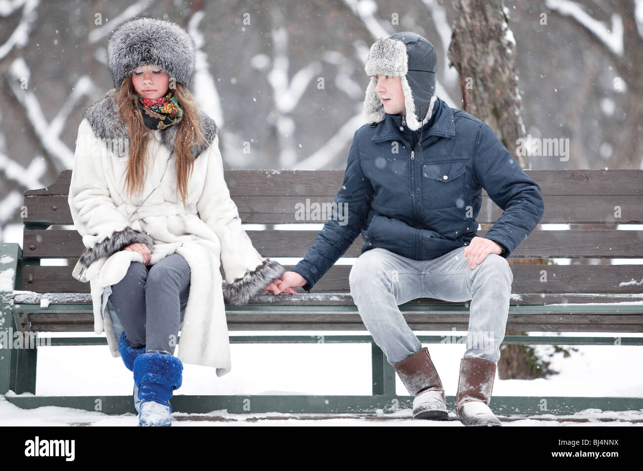 Young couple sitting on a bench in a park Stock Photo - Alamy