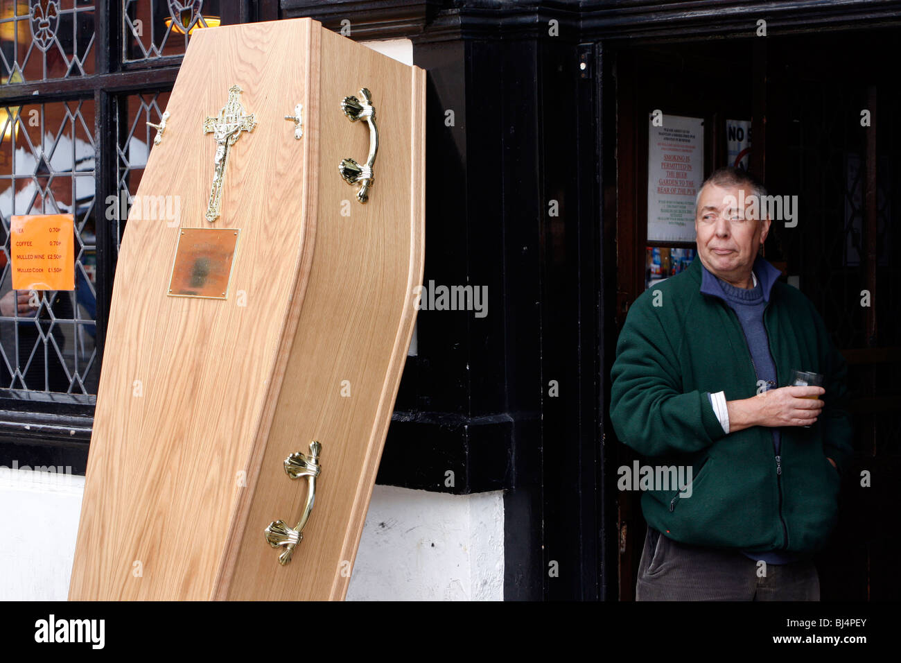 Male thinking & drinking at the side of a coffin outside 'Ye Olde Man & Scyth' public house in Bolton , England  UK.  photo Don Tonge Stock Photo