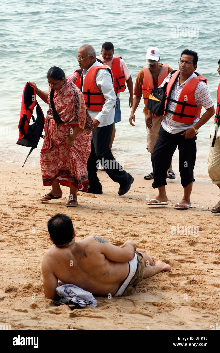 Asian tourists wearing life jackets on the Beach after a Boat Trip Stock Photo