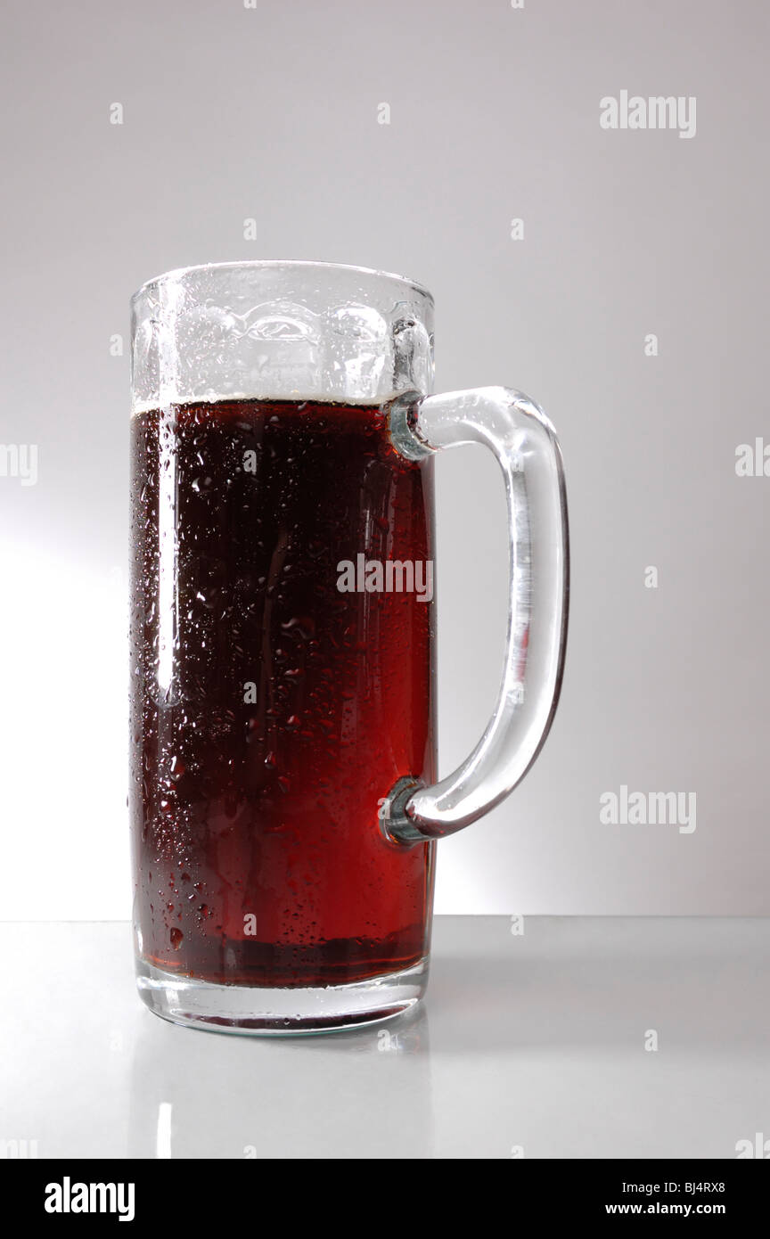 Glass of dark beer over gray background Stock Photo