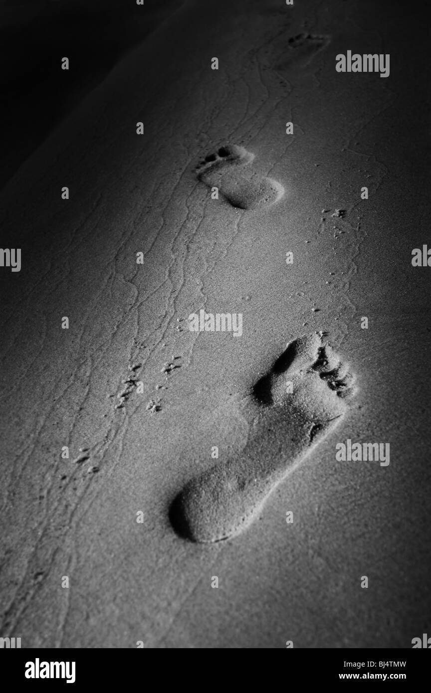 Human footprints on sand. Walk along the beach conceptual photo Stock Photo