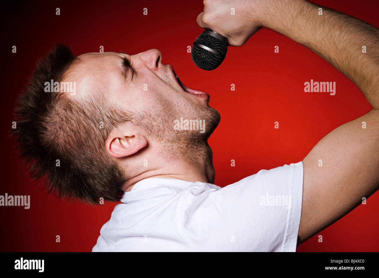 young man screaming to the microphone Stock Photo