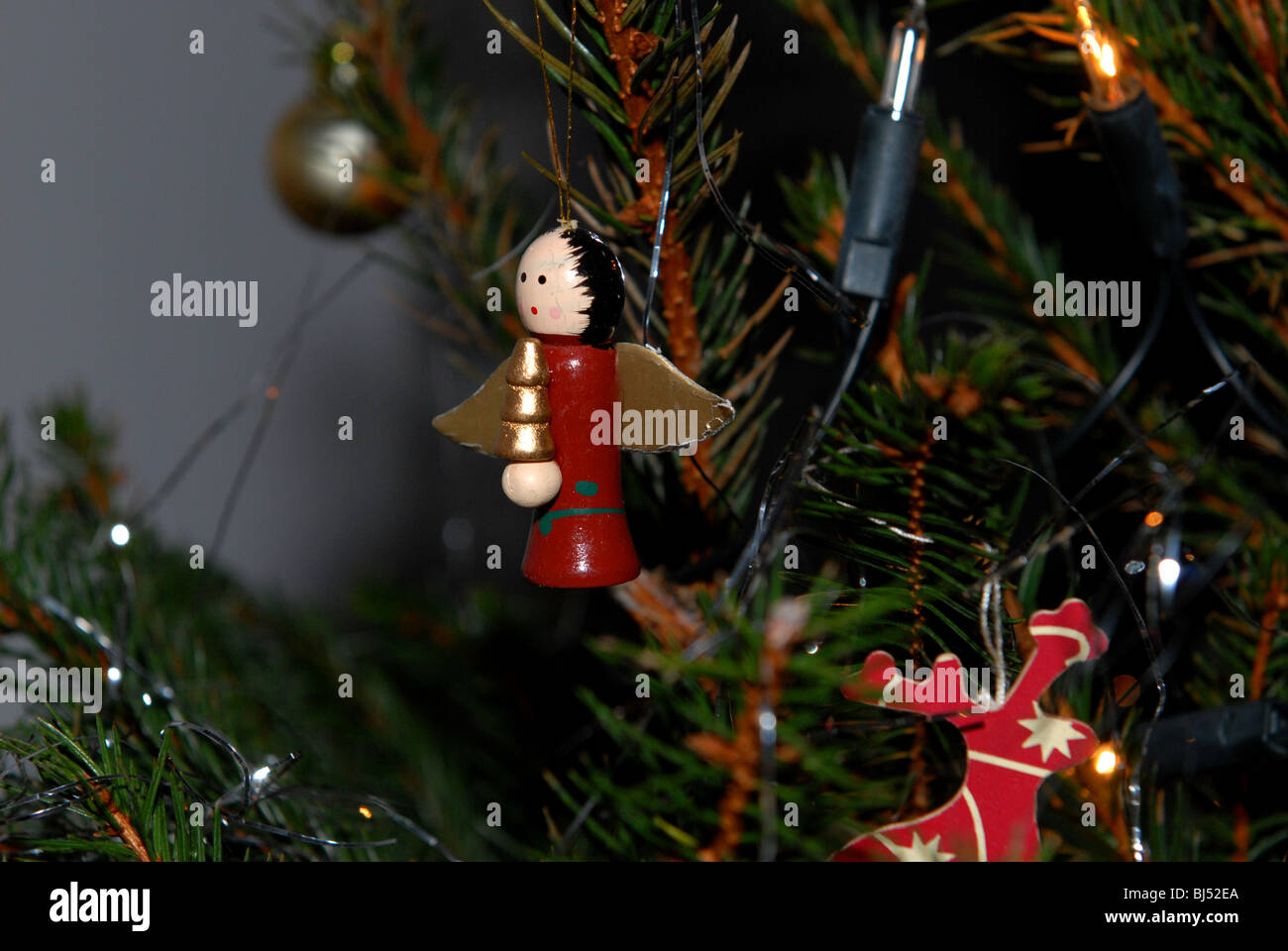 Traditional wooden Christmas tree decorations on a real tree brought indoors and decorated for