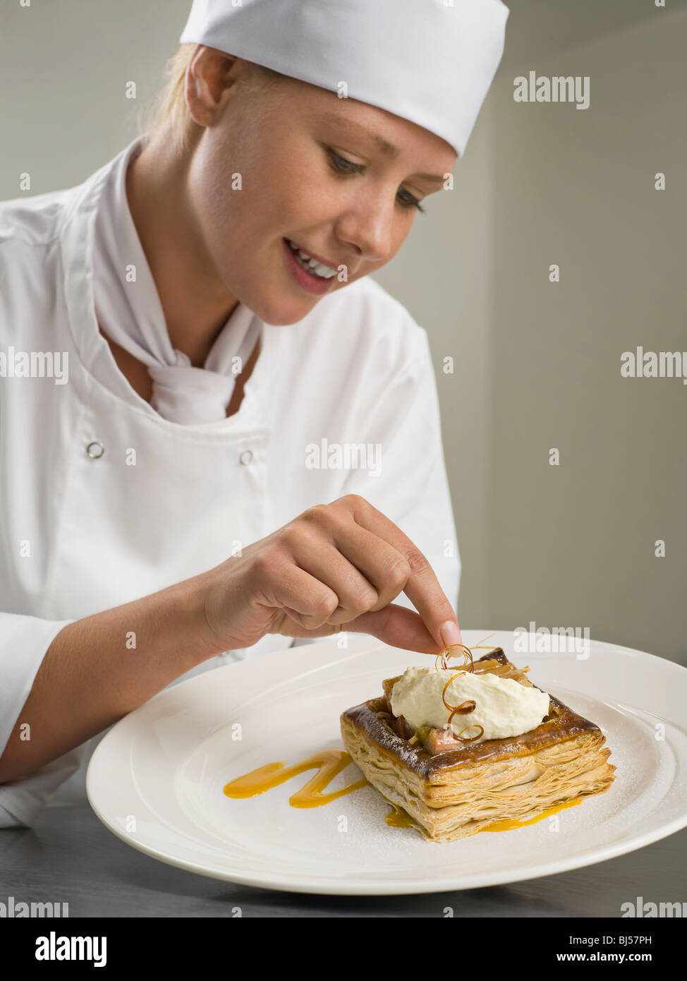 A female chef finishing a desert Stock Photo