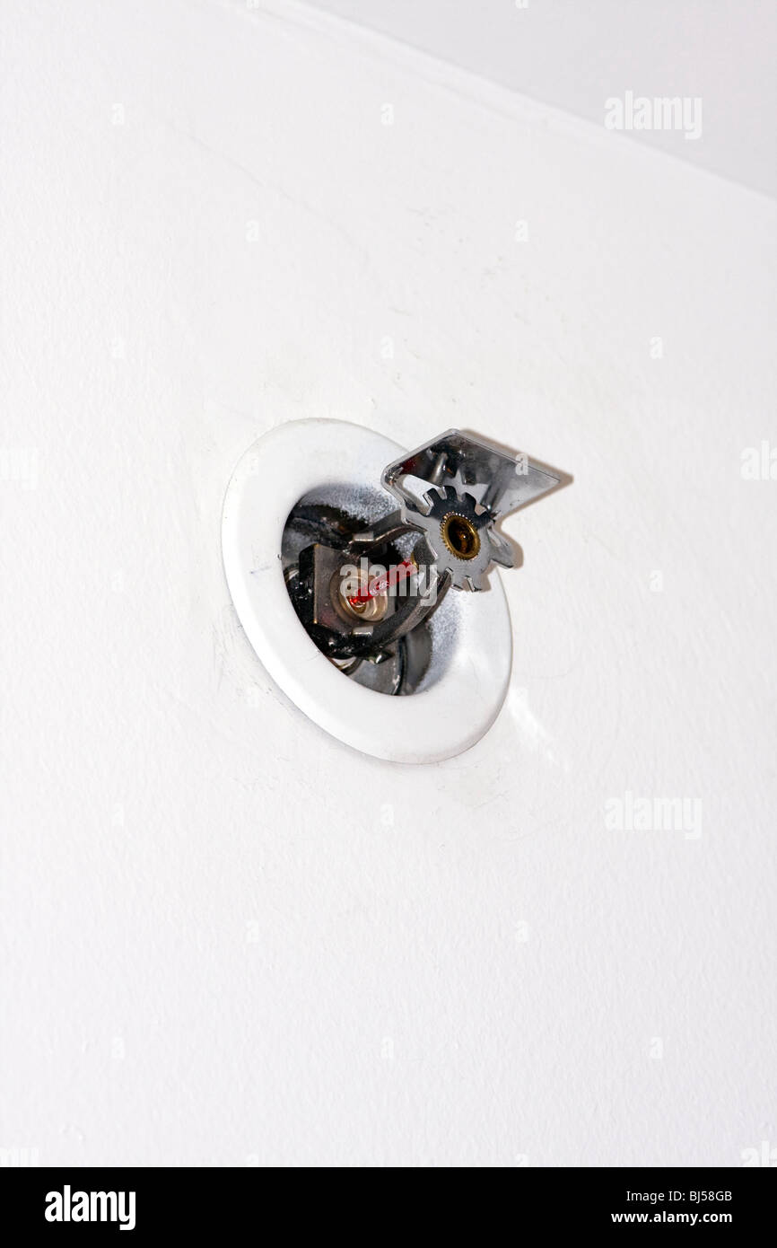 Recessed Pendant Horizontal Sidewall Sprinkler Head in white wall with directional nozzle. Stock Photo