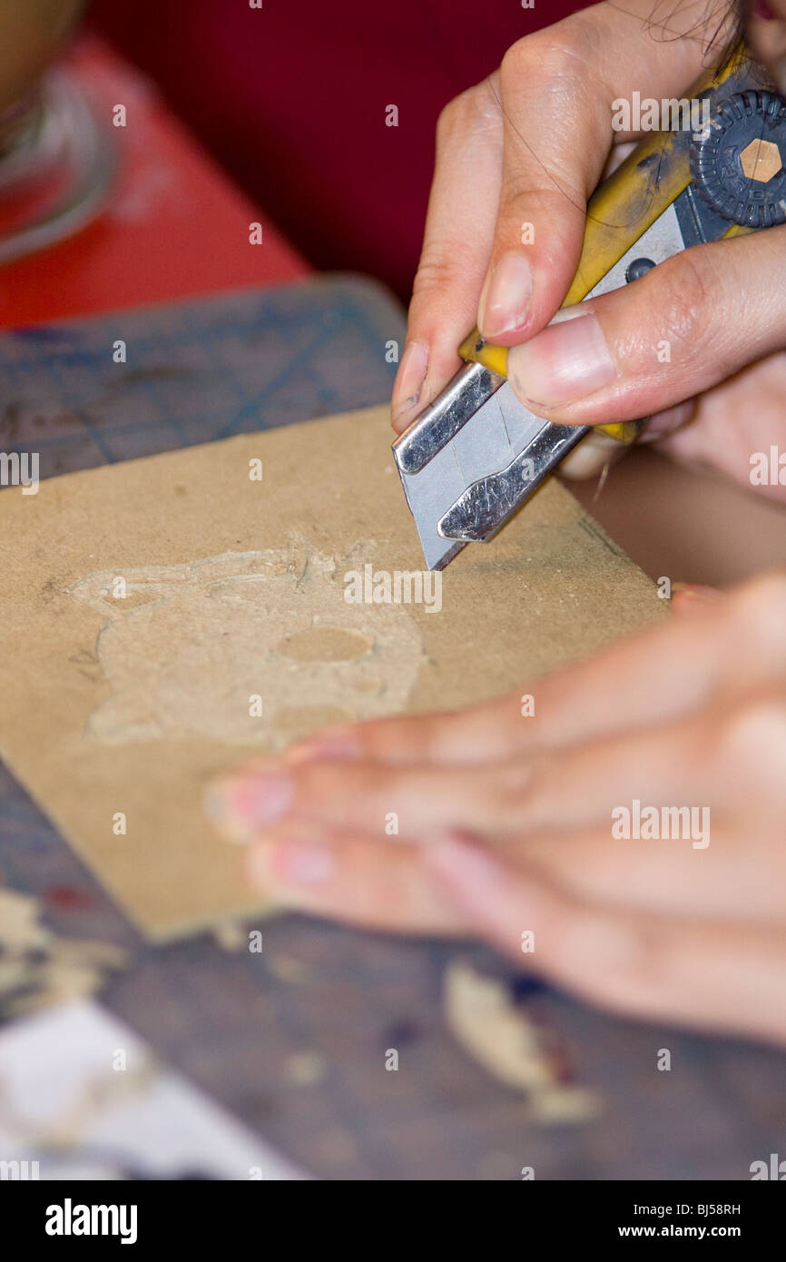 Artist using a Razor Blade Knife to cut an engraving into book board