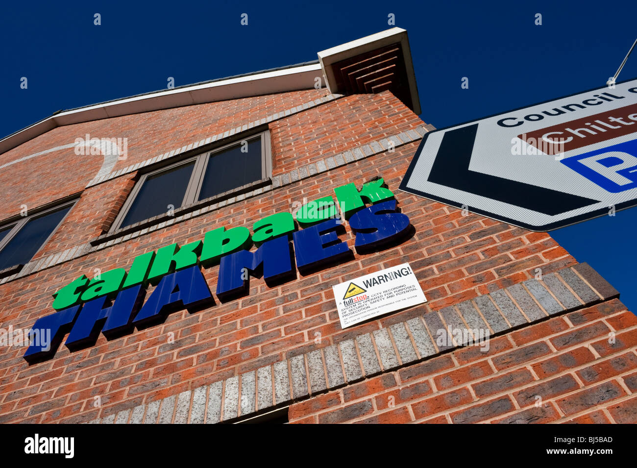 signs on the side of a modern brick built office building a business in