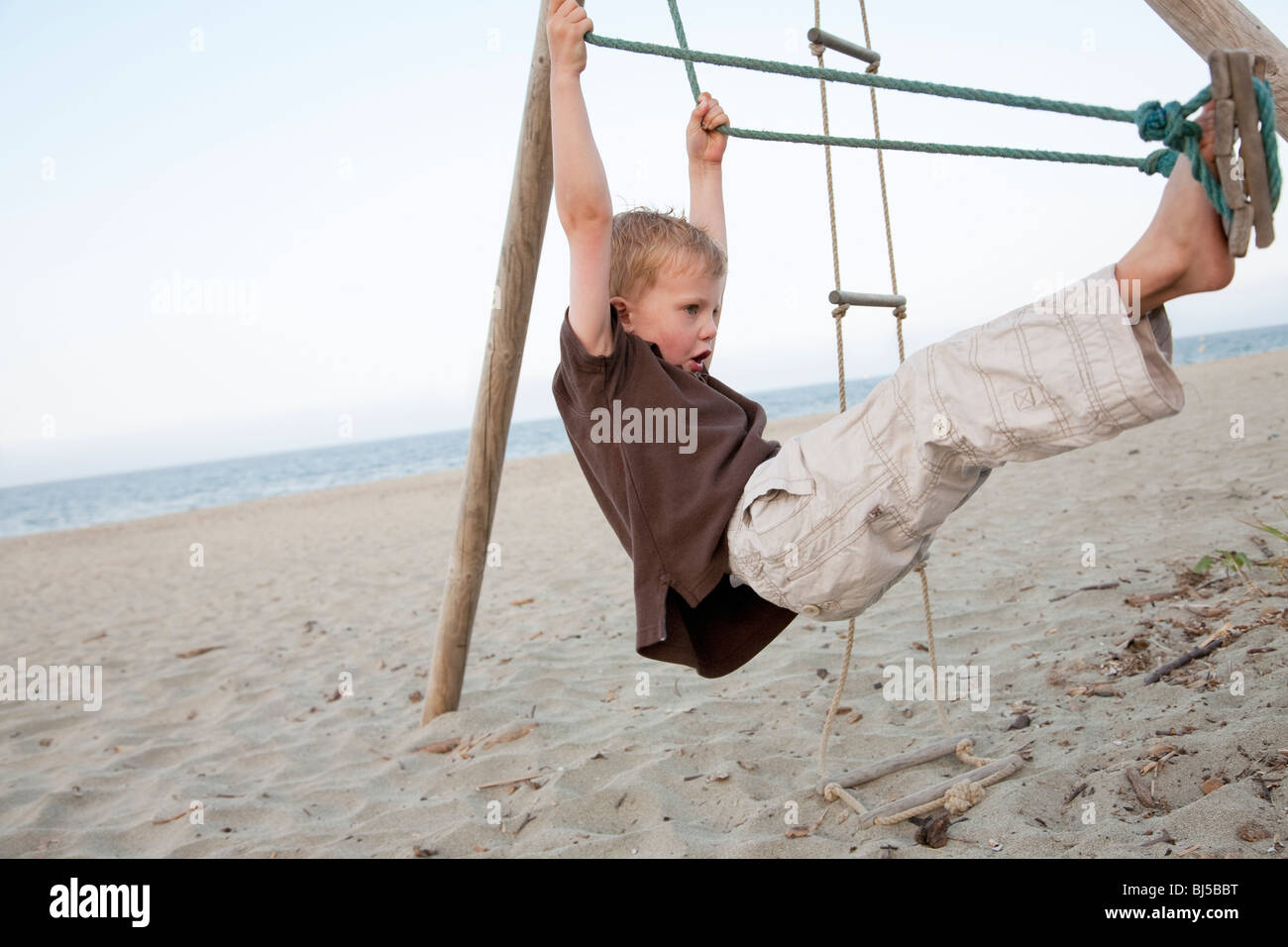 Boy on a swing at the beach Stock Photo