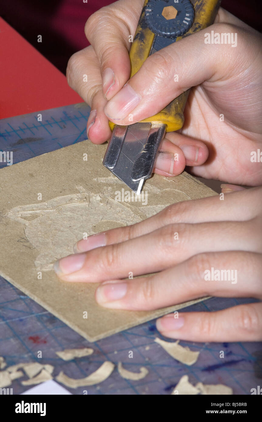 Artist using a Razor Blade Knife to cut an engraving into book board