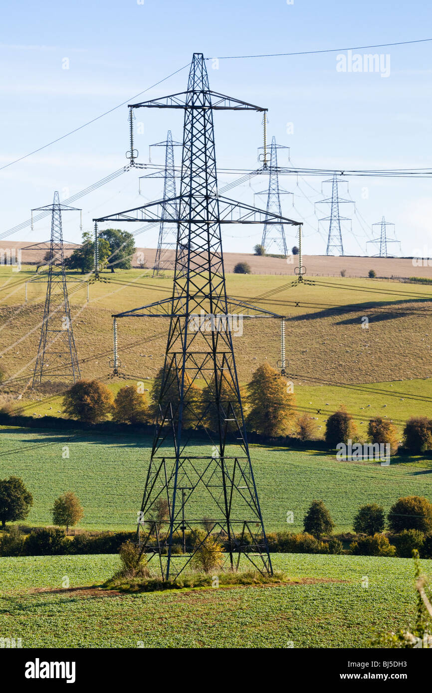 Pylons striding across the Cotswold countryside near Cassey Compton, Gloucestershire Stock Photo