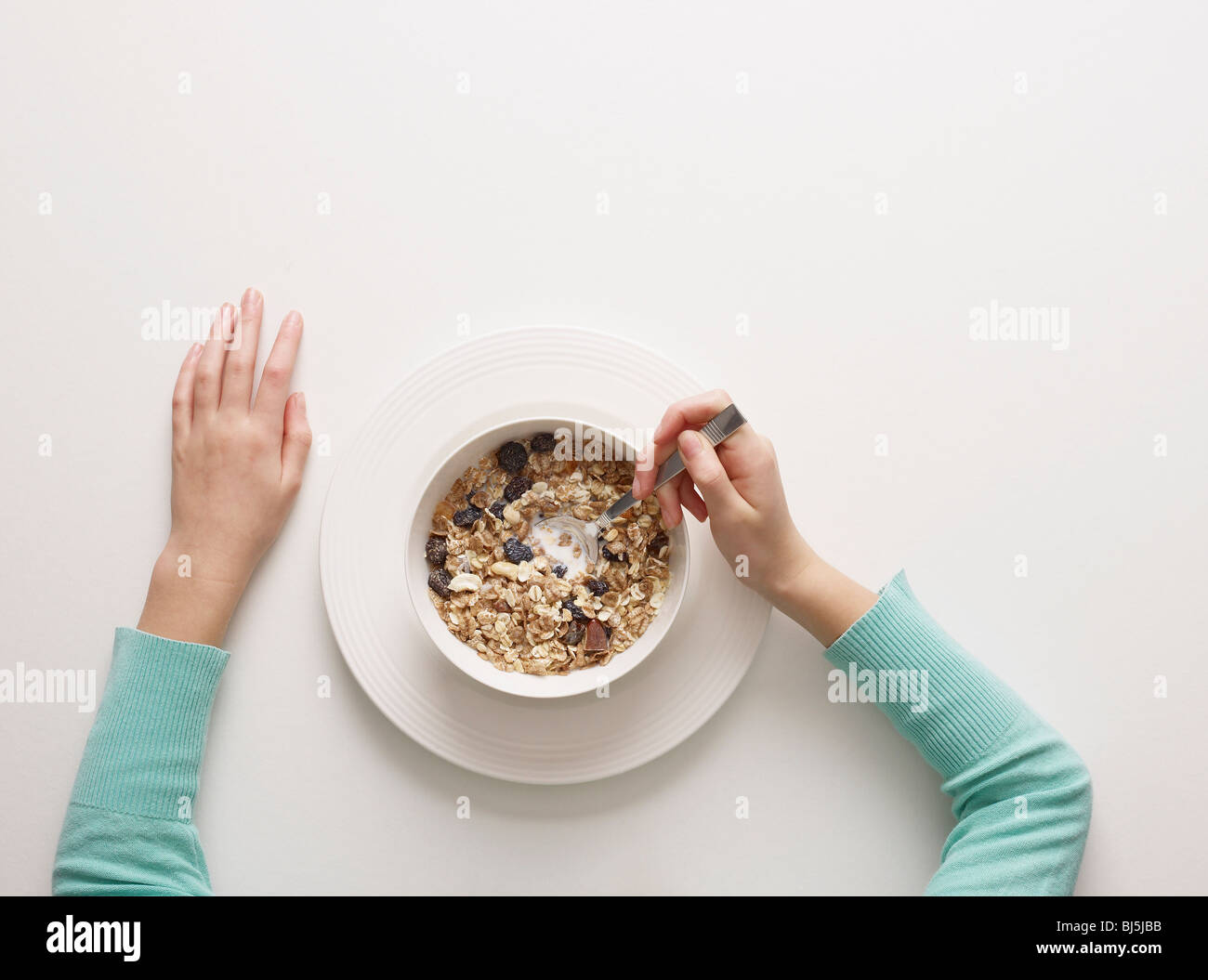 Hands by a bowl of cereal Stock Photo