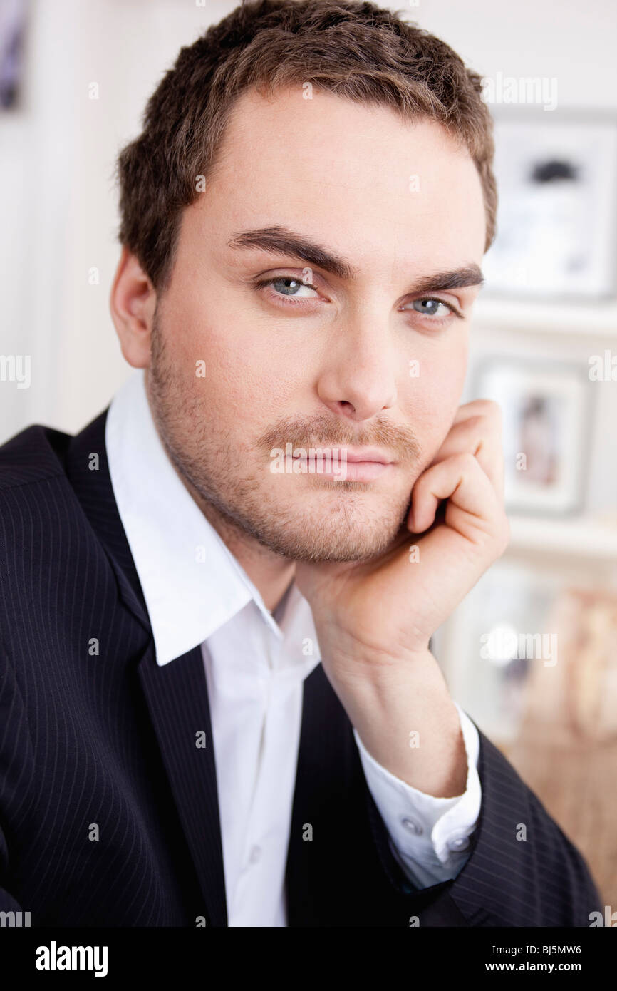 serious looking man resting chin on hand Stock Photo Alamy