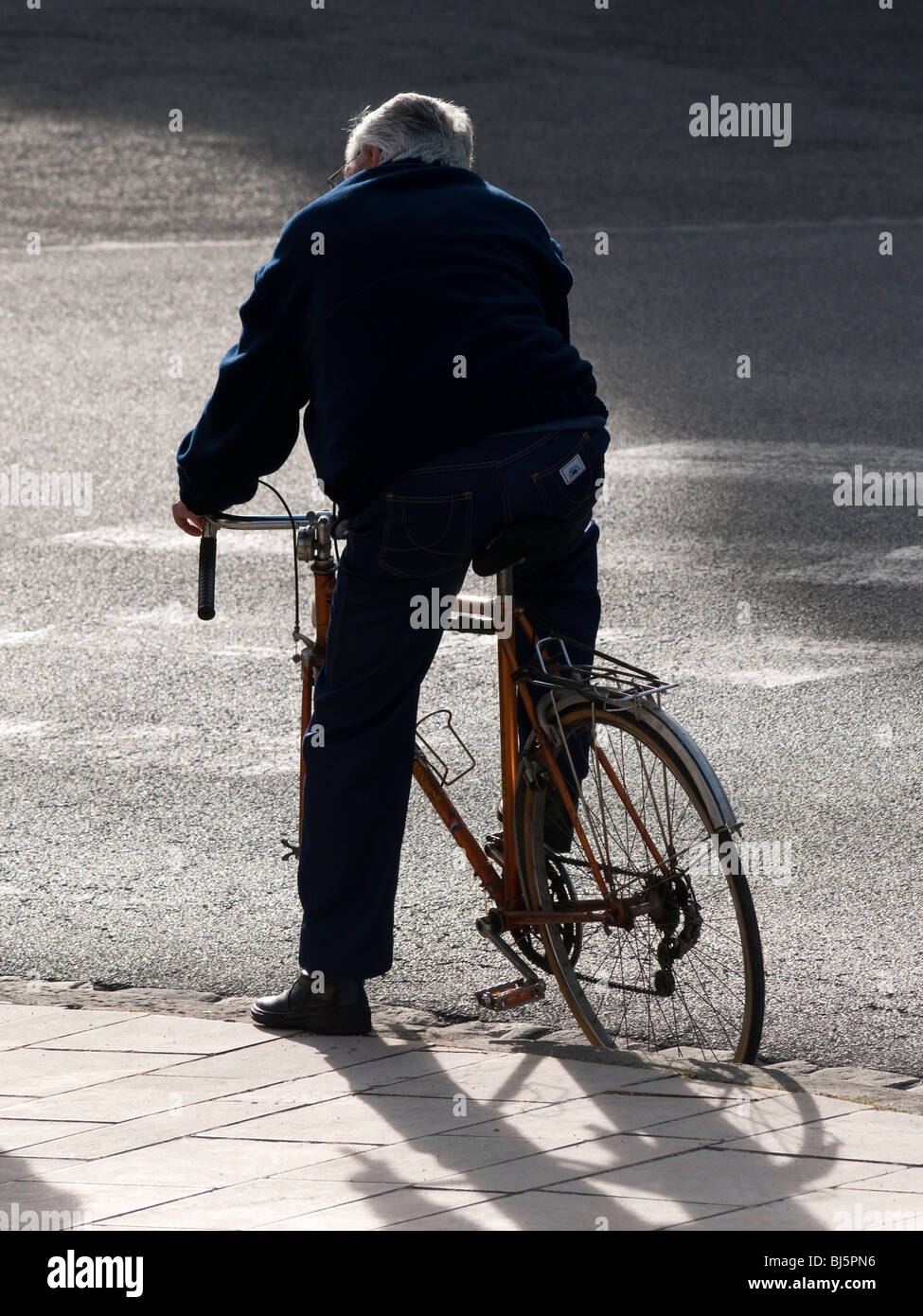 Cyclist waiting at kerb - France. Stock Photo