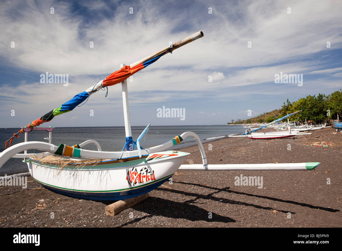 Indonesia, Bali, Amed, colourfully painted outrigger fishing boats on the black volcanic sand beach Stock Photo