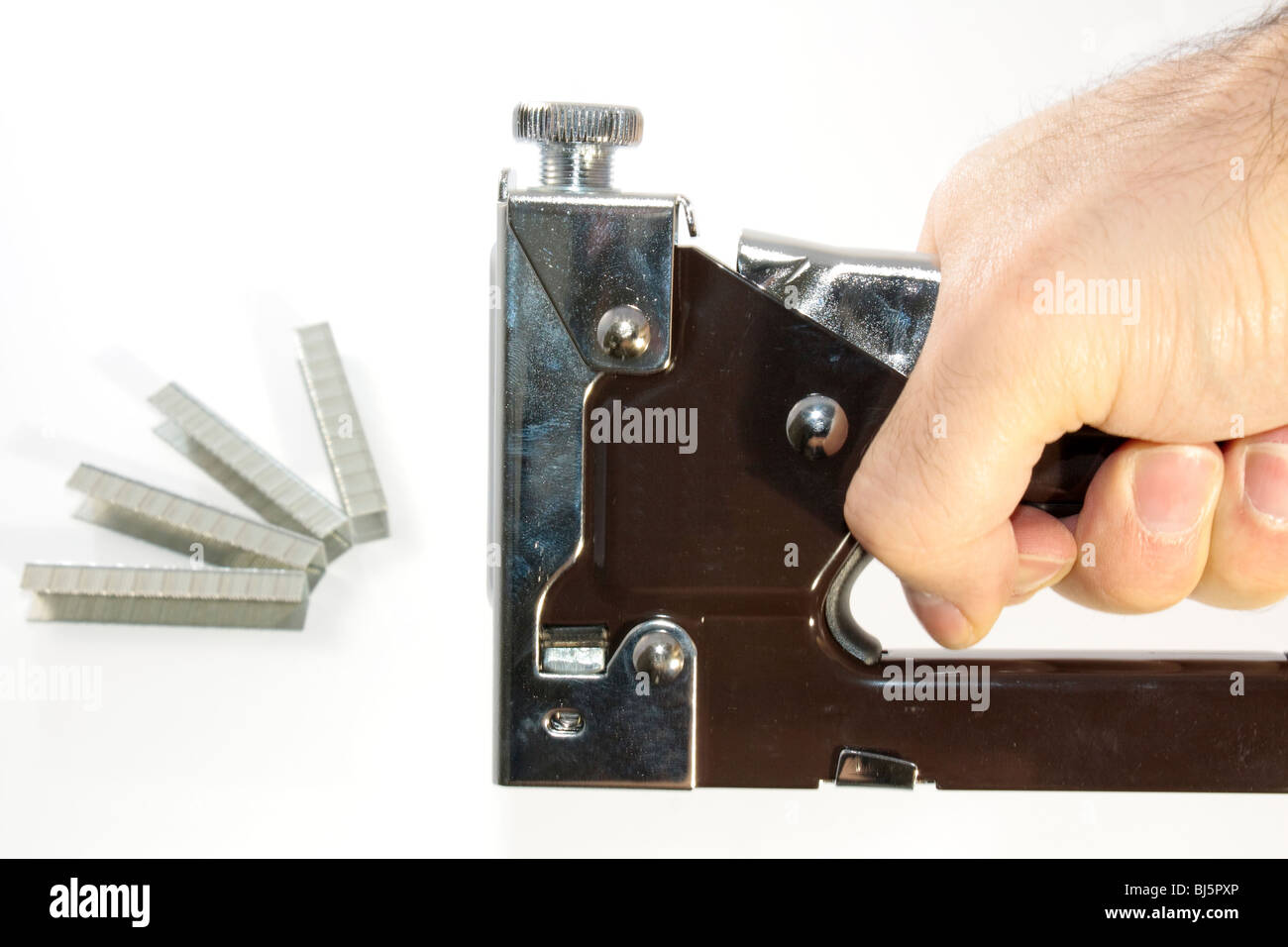 hand staple gun with staples in distance isolated against white