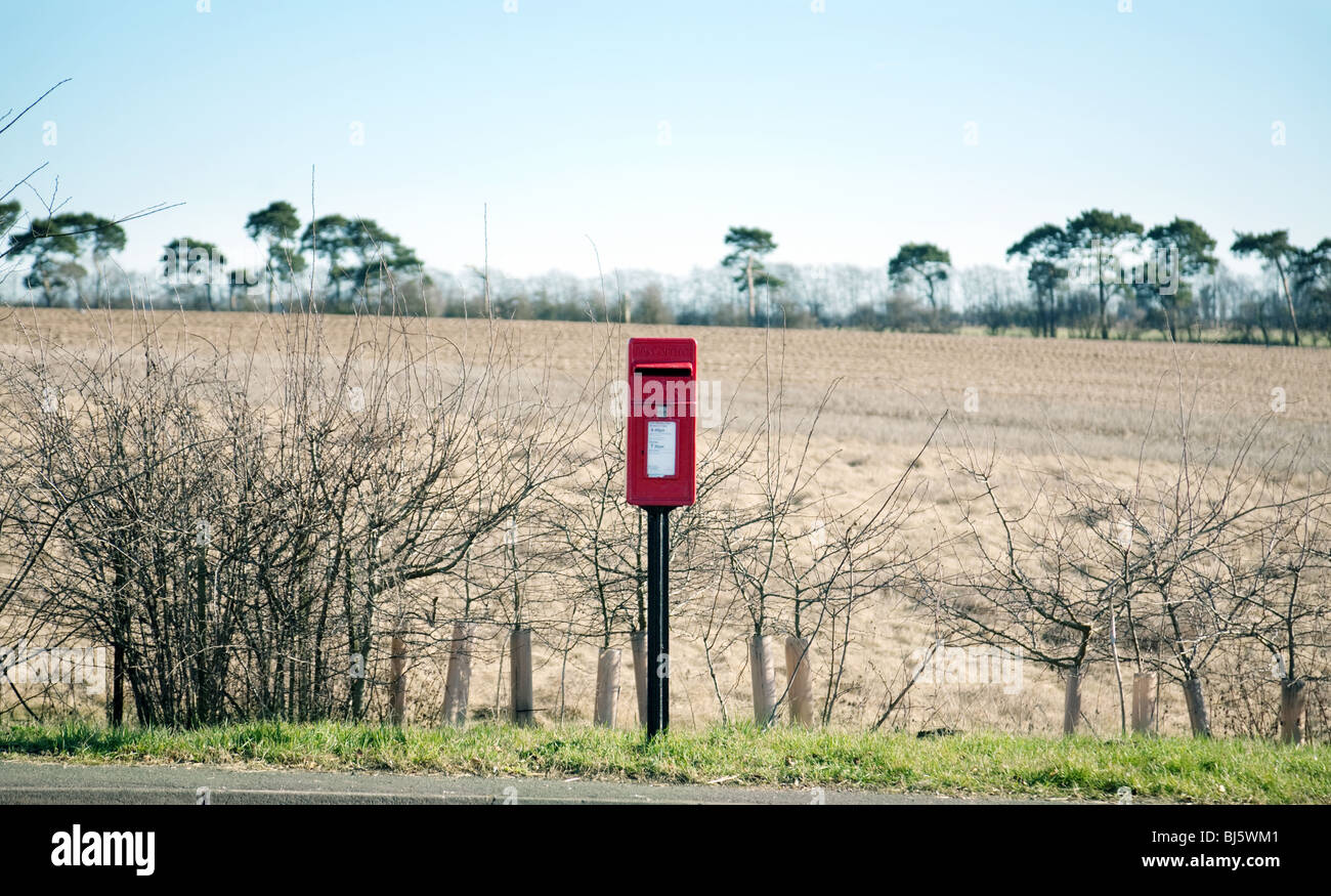 red post box on a country road, suffolk, UK Stock Photo