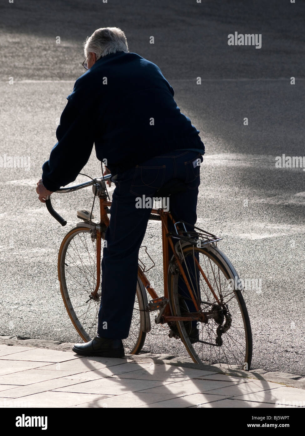 Cyclist waiting at kerb - France. Stock Photo