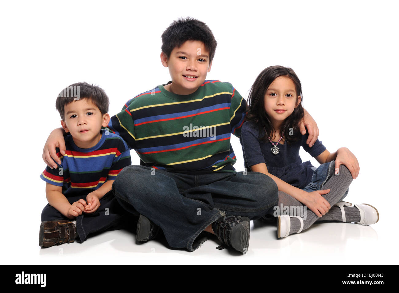 Three siblings sitting together over white background Stock Photo