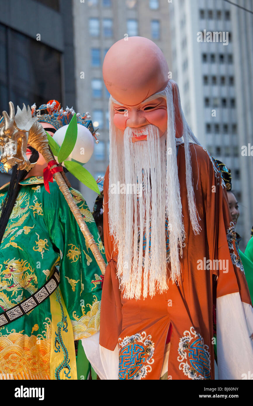 Person walking on stilts in wise old Chinese man costume participates in Chinese New Year's Parade in San Francisco, California. Stock Photo