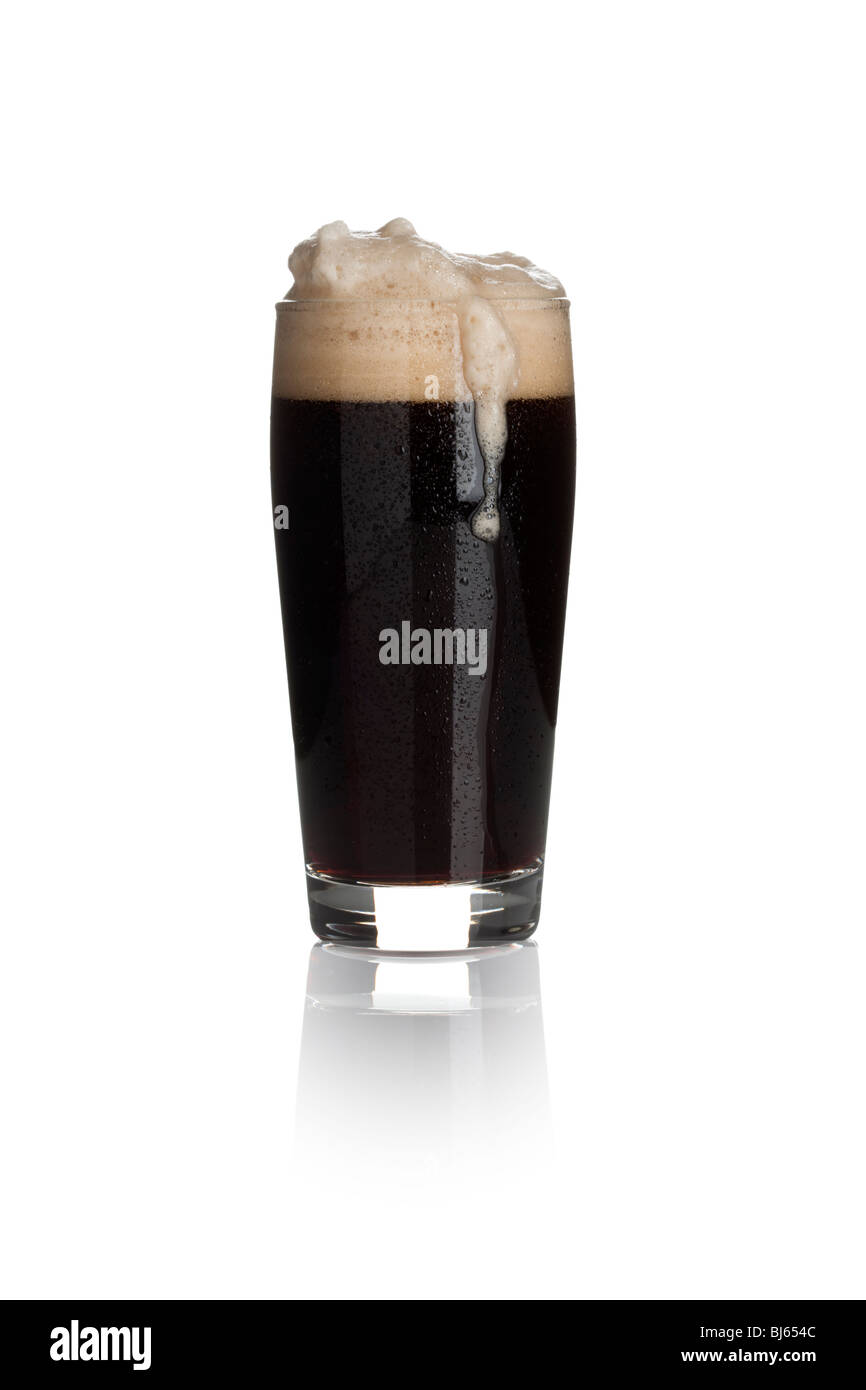 a glass of stout with froth and dew drops isolated on white background Stock Photo