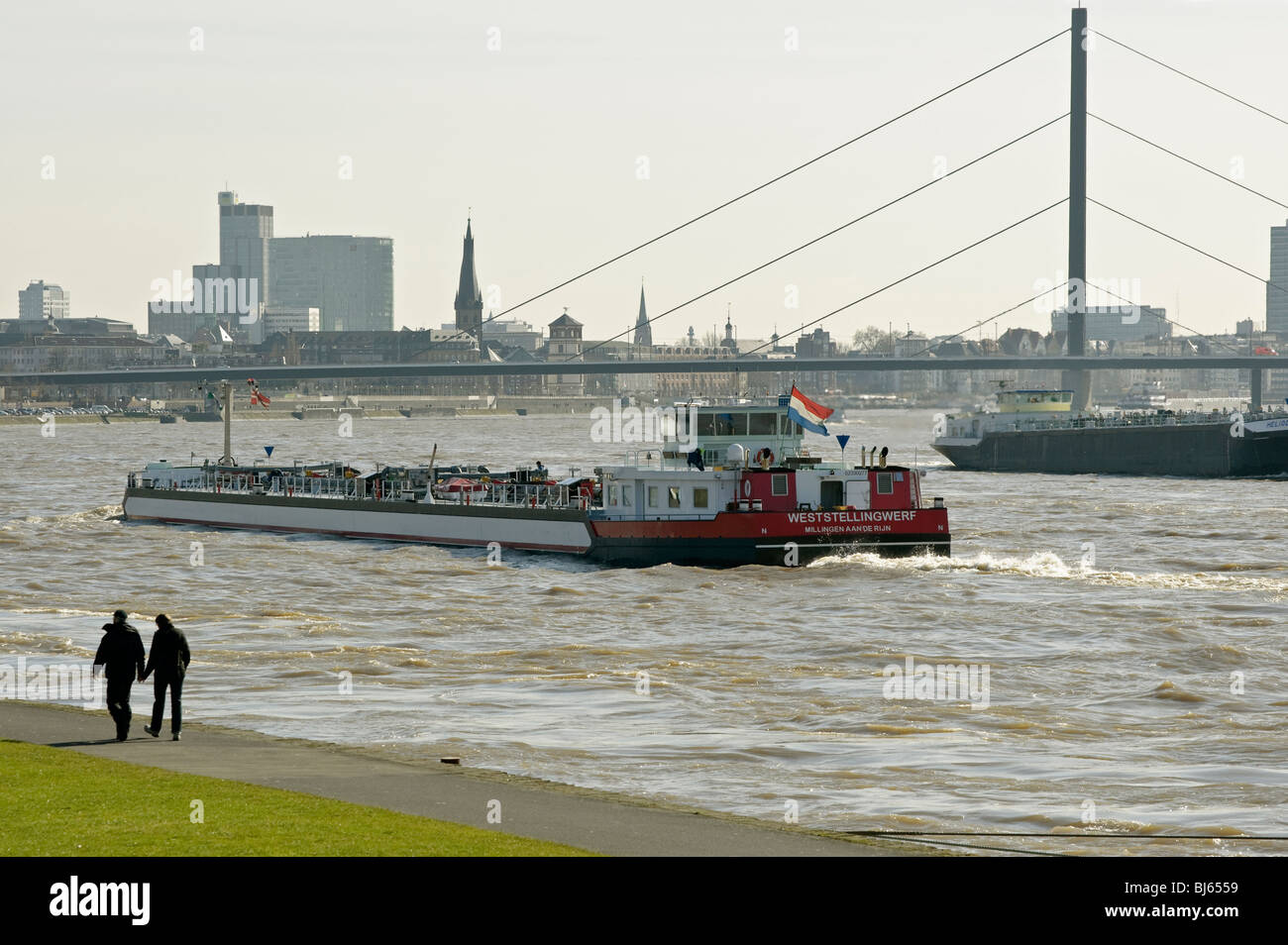 Barges on the Rhine with view of  Oberkassel Bridge and Düsseldorf, Germany. Stock Photo