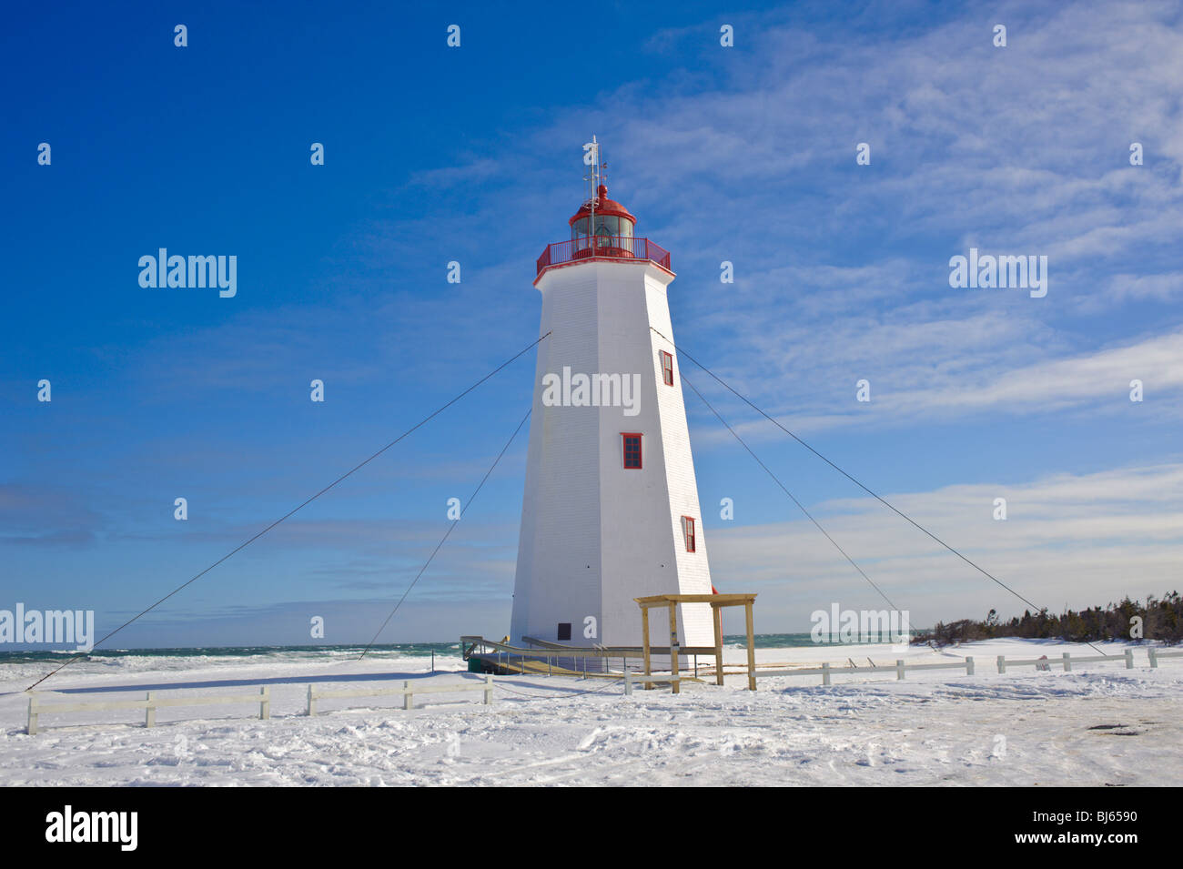 Miscou Island lighthouse surrounded by snow and a very blue sky. Winter in Canada Stock Photo