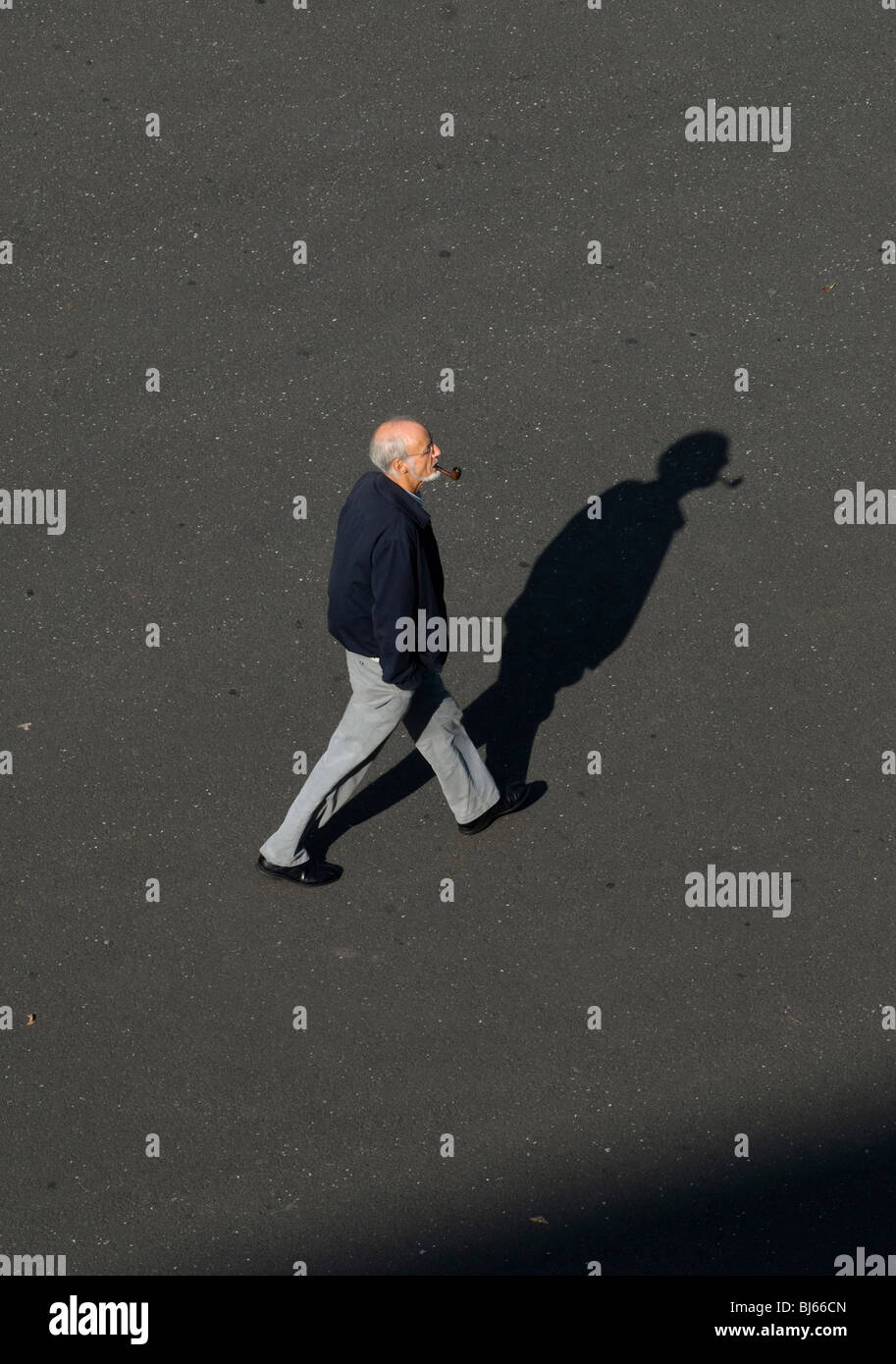 An old man with a pipe walking on the pavement in Basel, Switzerland Stock Photo