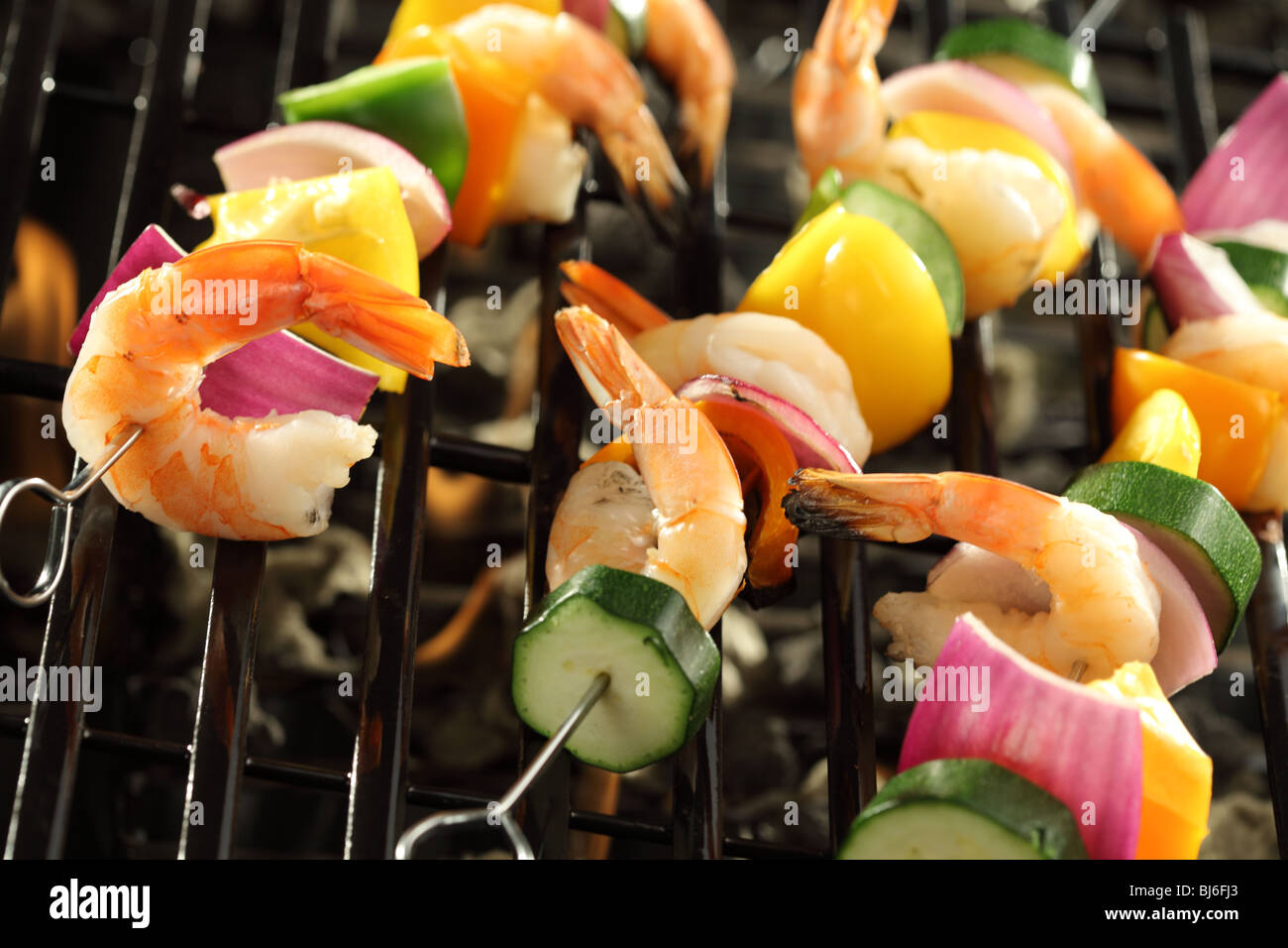 Shrimp and vegetable skewers cooking on grill Stock Photo
