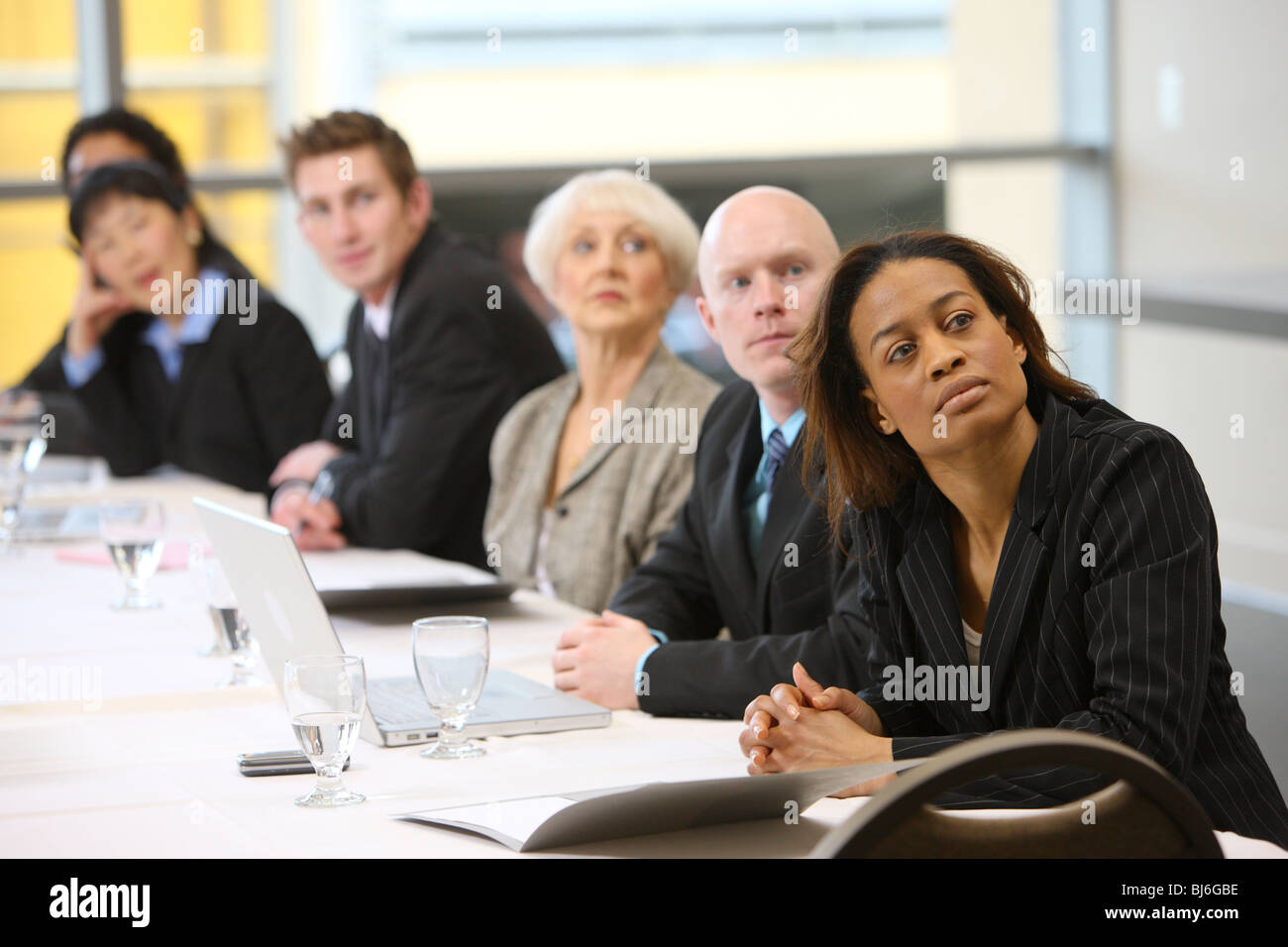 Businesspeople watch presentation in board room Stock Photo