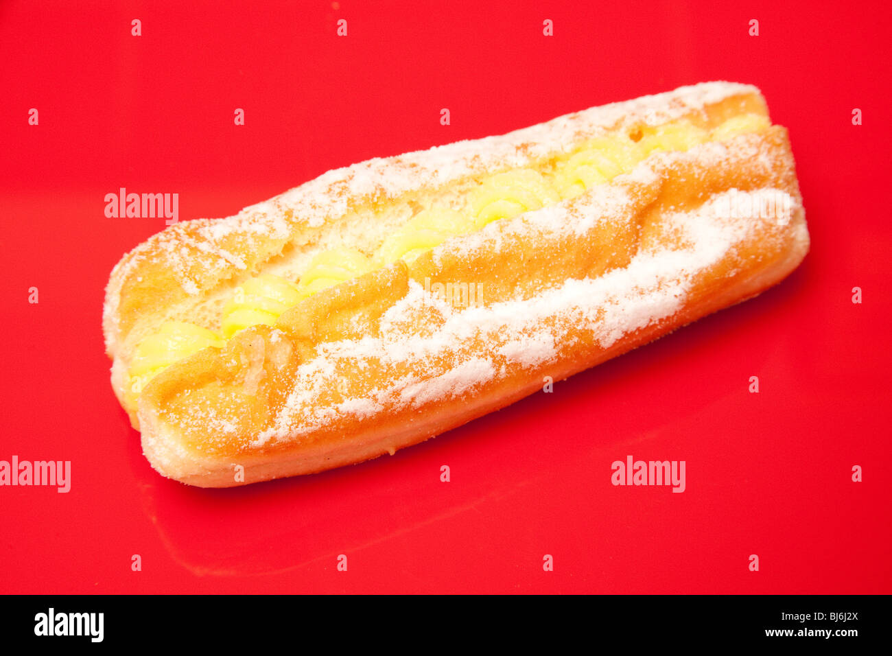 Custard cream donut  isolated on a red studio background. Stock Photo