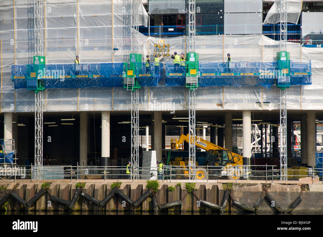 Workers on an access platform at the MediaCityUK development, Salford Quays, Greater Manchester, UK Stock Photo
