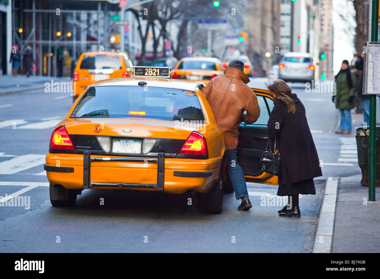 Getting into a cab in midtown Manhattan, New York City Stock Photo