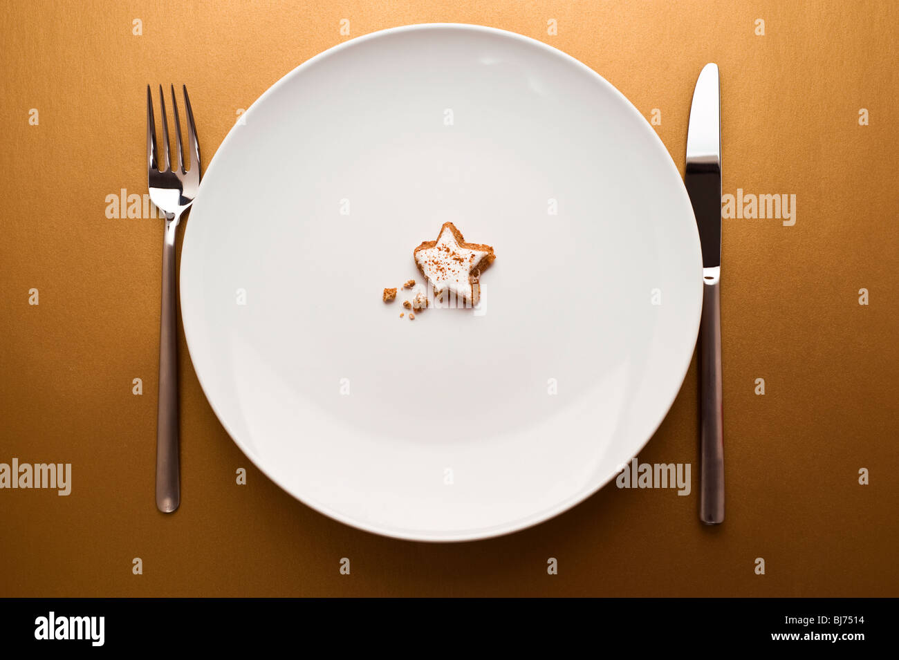 glazed nut cookie on dish on gold background Stock Photo