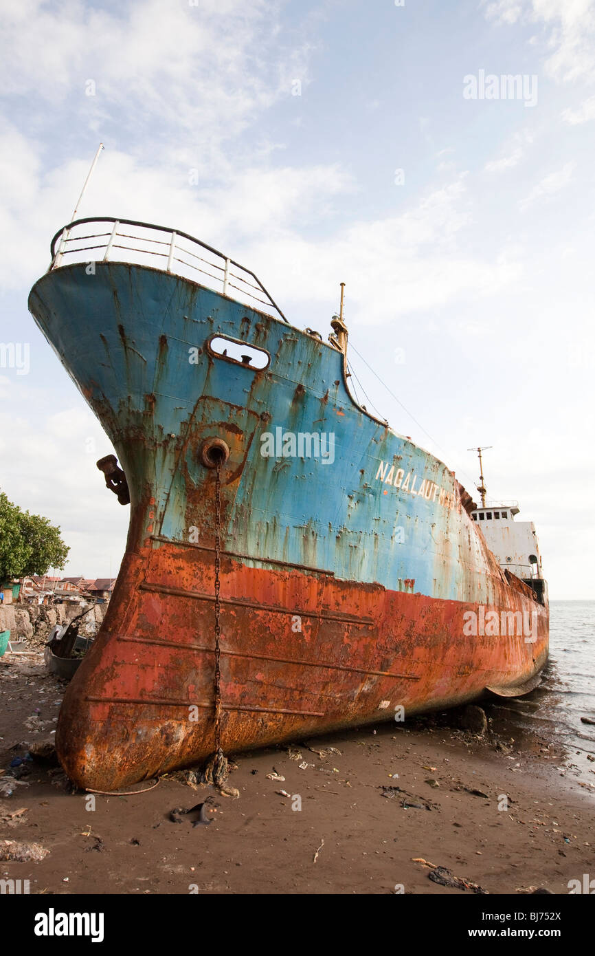 Indonesia, Sulawesi, Makassar, seafront, merchant ship run aground on the beach Stock Photo