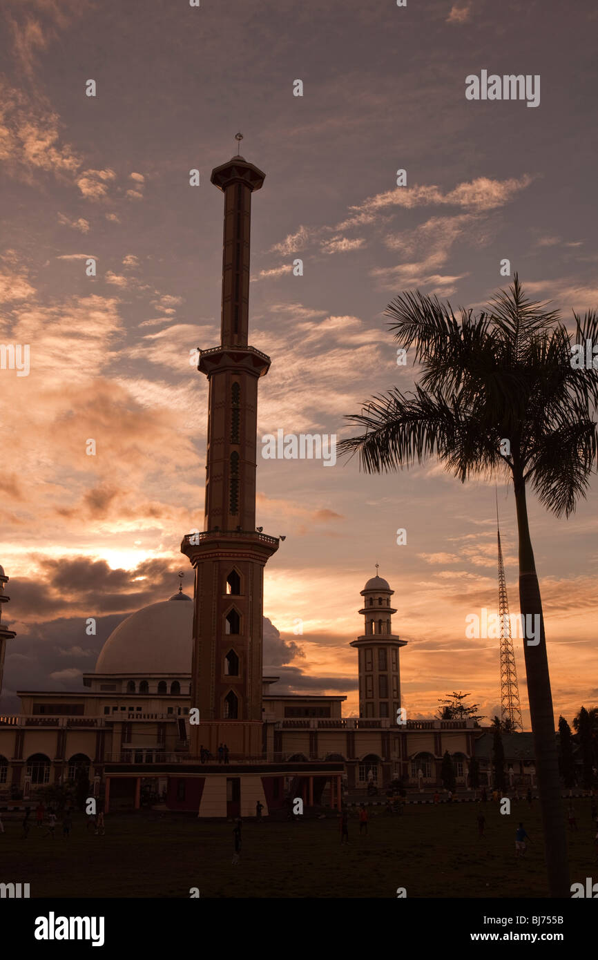 Indonesia, Sulawesi, Sengkang, tall minaret of main mosque high above town skyline at sunset Stock Photo