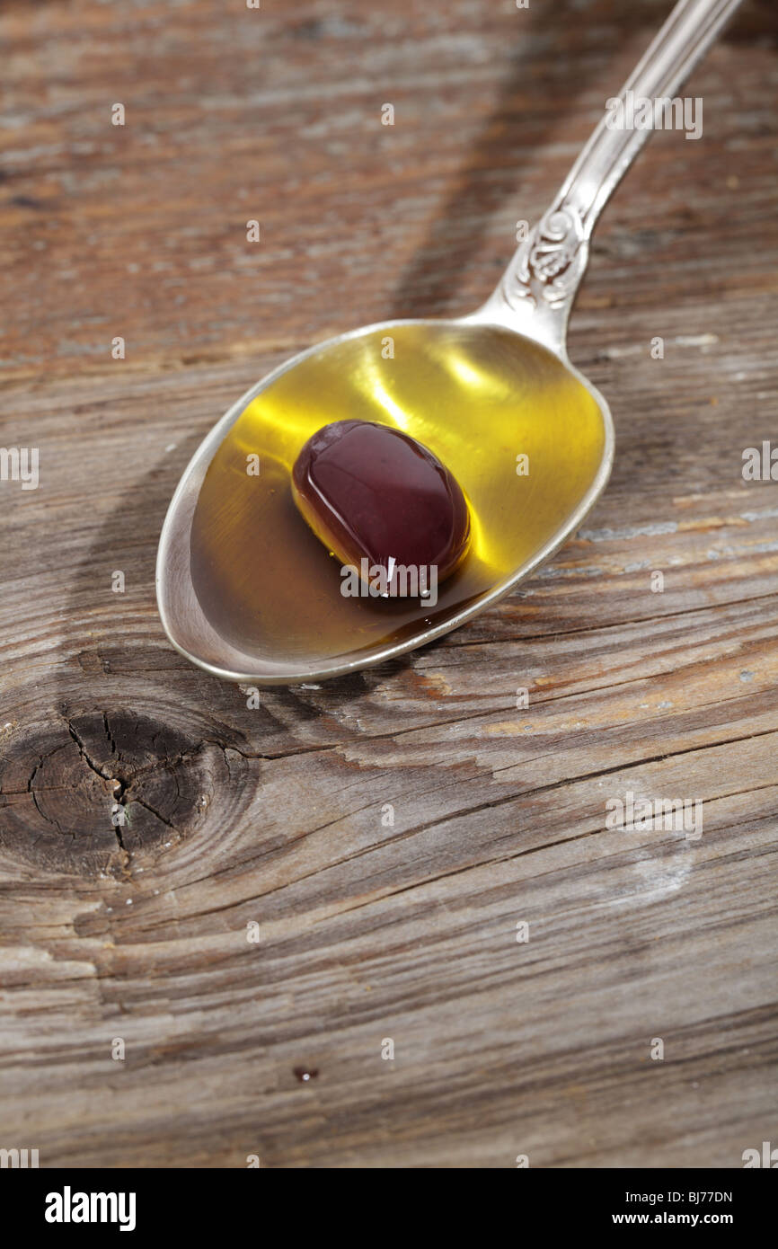 Olive in a spoon with olive oil Stock Photo Alamy