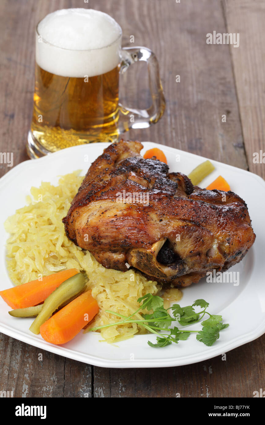 Eisbein with sauerkraut and beer on white plate Stock Photo