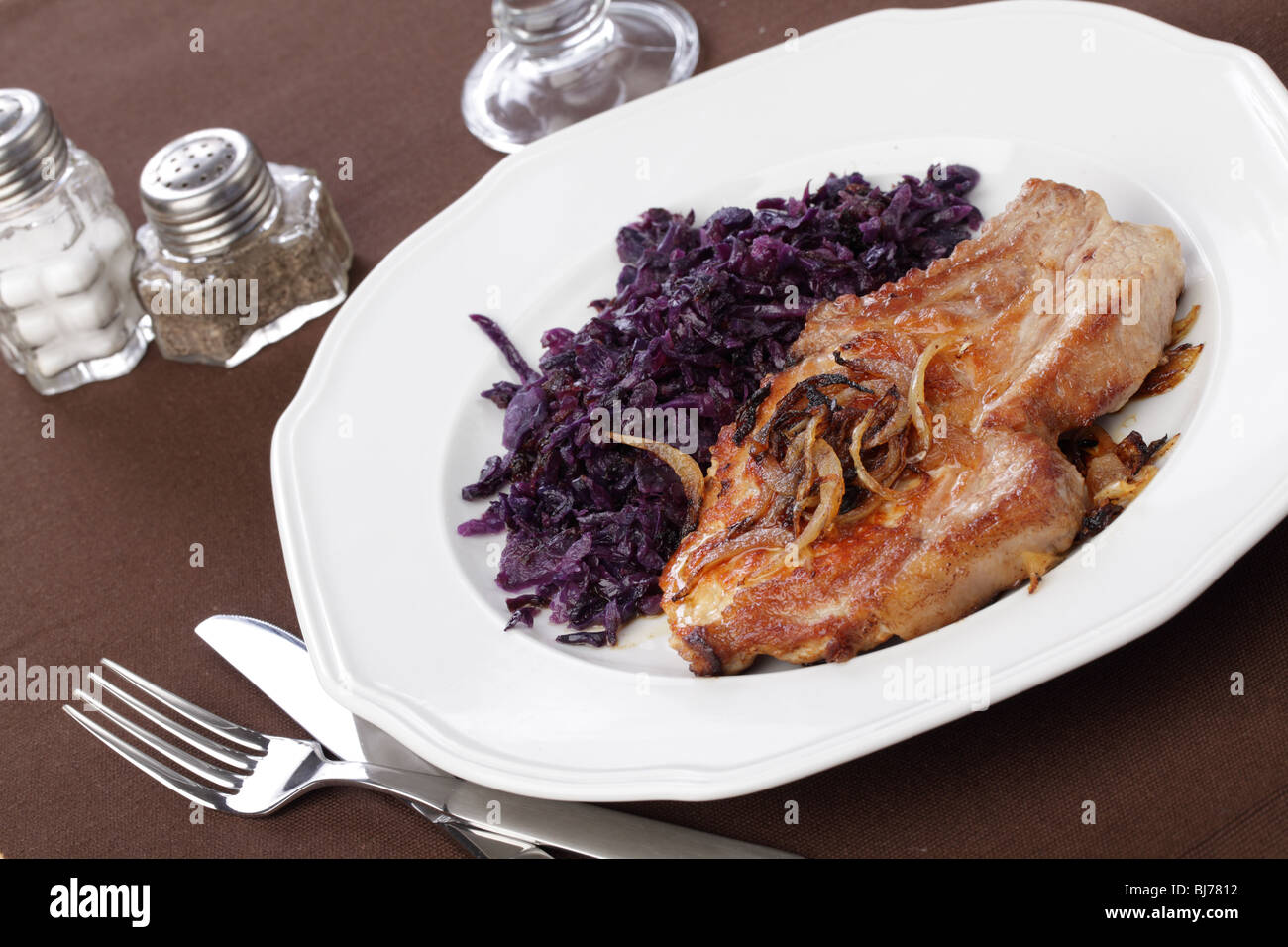 Roasted pork cutlet with blue kraut on white plate Stock Photo
