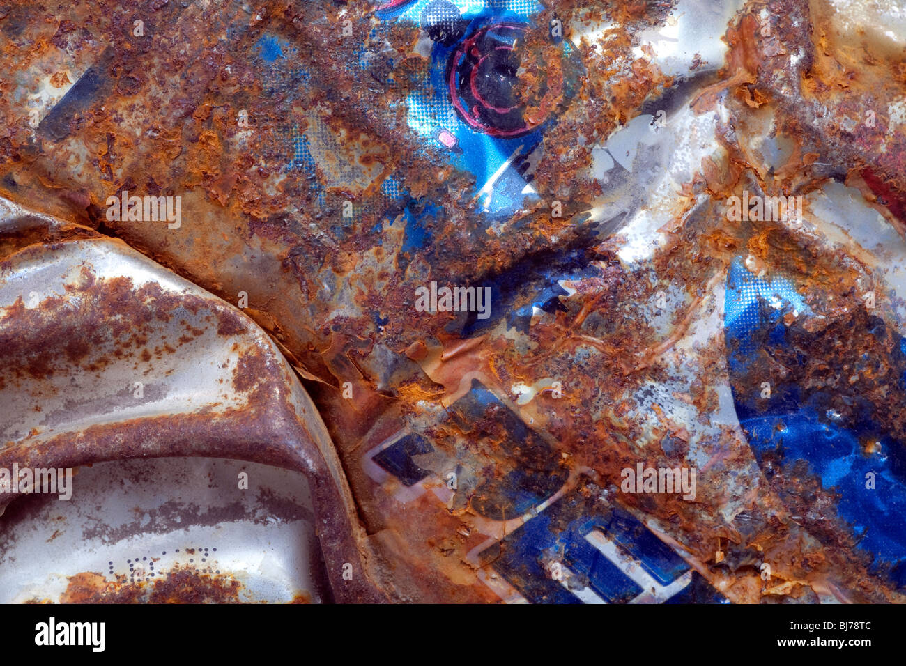 Detailed image showing the texture/colour of a discarded/compressed soft drinks can that has been found littering a city street. Stock Photo