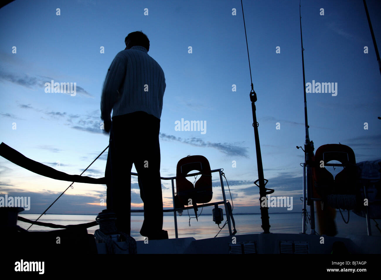Man angling on a sailing boat Stock Photo