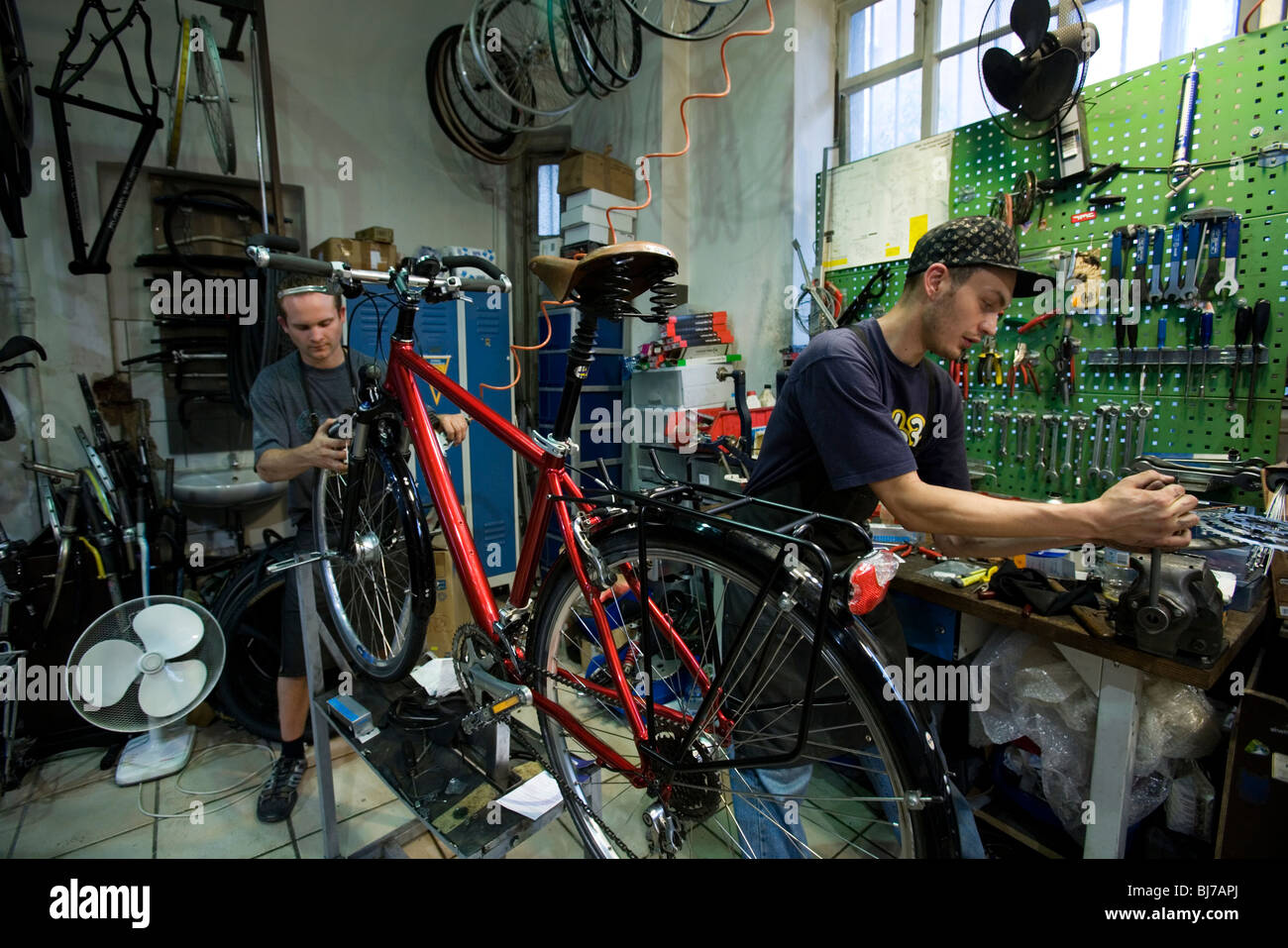 Two men working in a Bicycle repair shop, with tools of the trade Stock