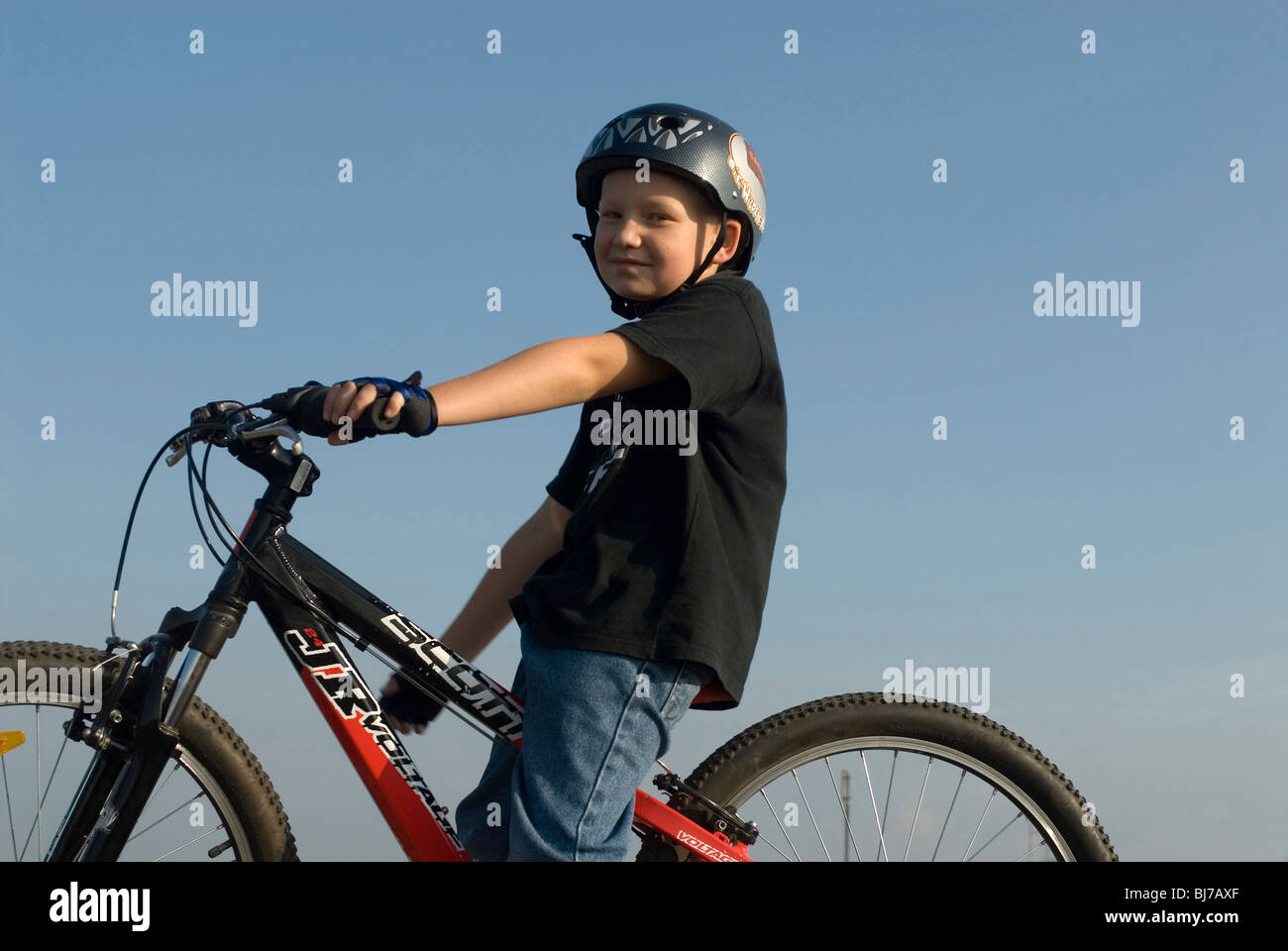 8-year-old boy sitting on his mountain bike Stock Photo