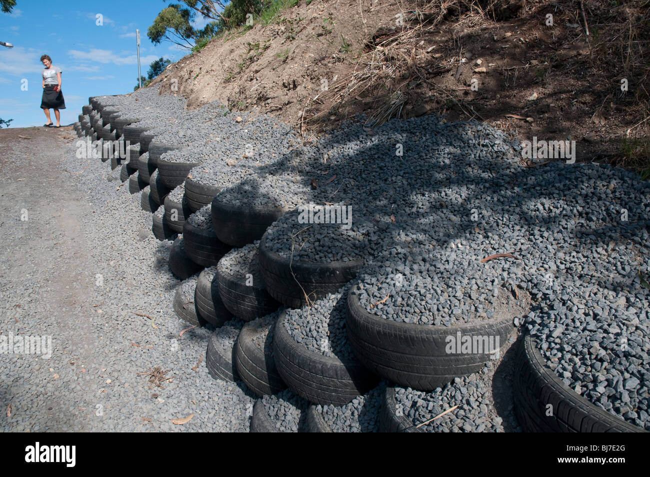 Recycled tyres and gravel used as a retaining wall on a driveway Stock Photo