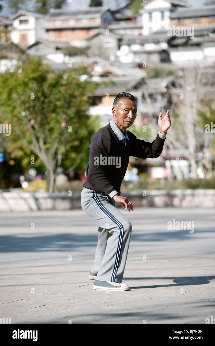Man practising tai chi in early morning in tourist town of Lijiang, Yunnan province, China. Stock Photo