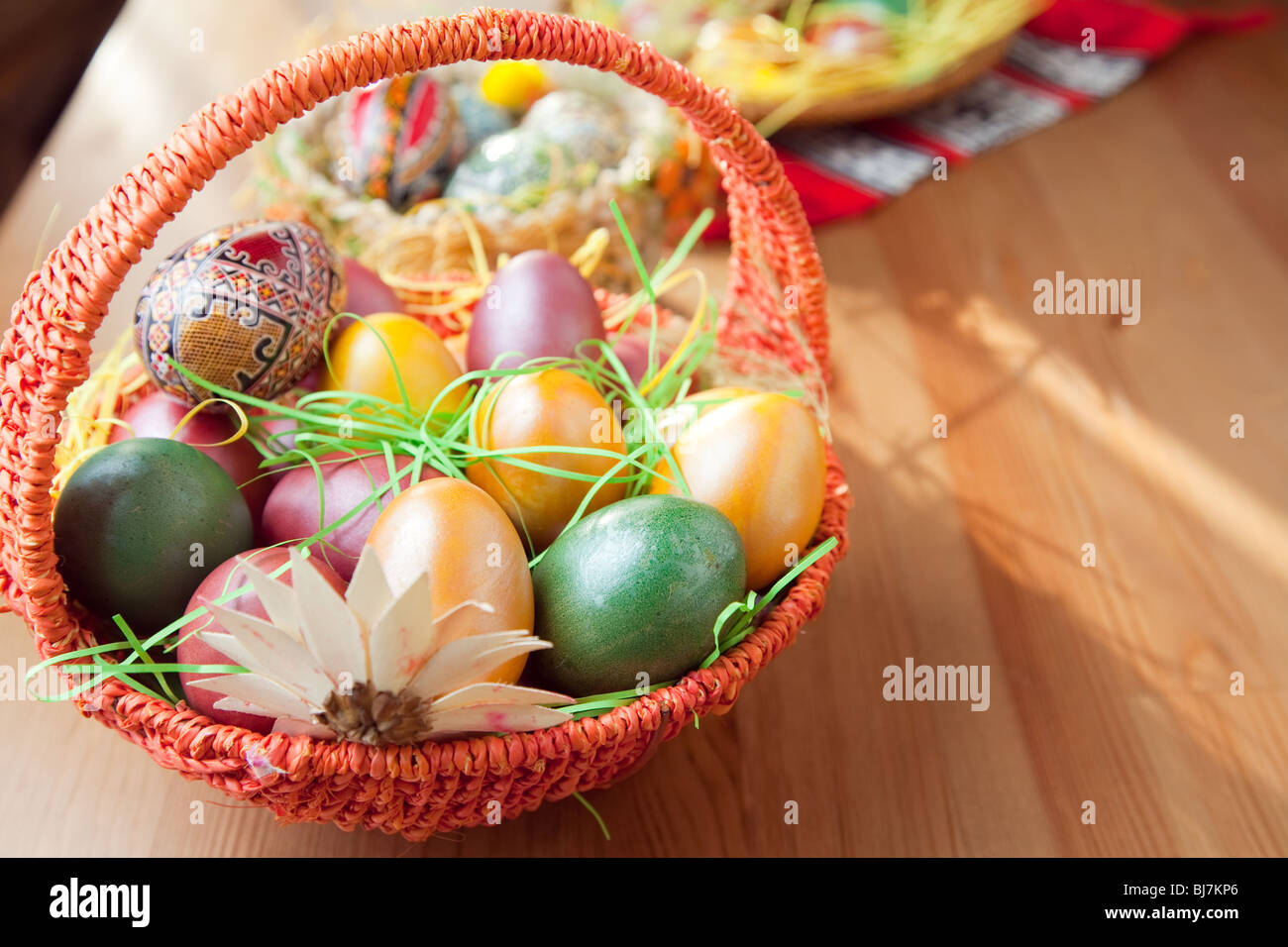 Easter painted eggs in traditional basket on table Stock Photo